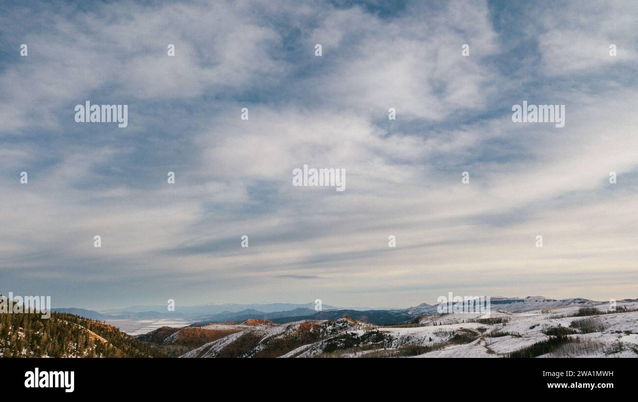 Drone shot du ciel avec des nuages et des collines couvertes de neige Banque D'Images