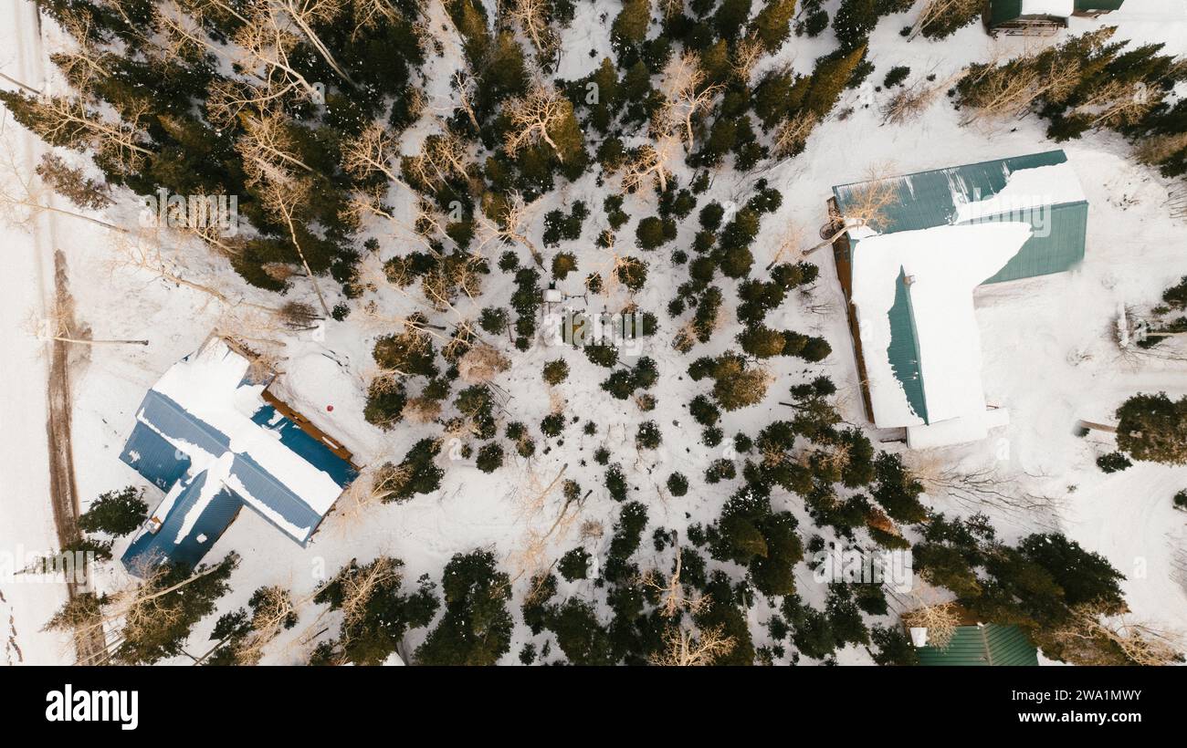 Deux cabanes séparées par une forêt enneigée en montagne Banque D'Images