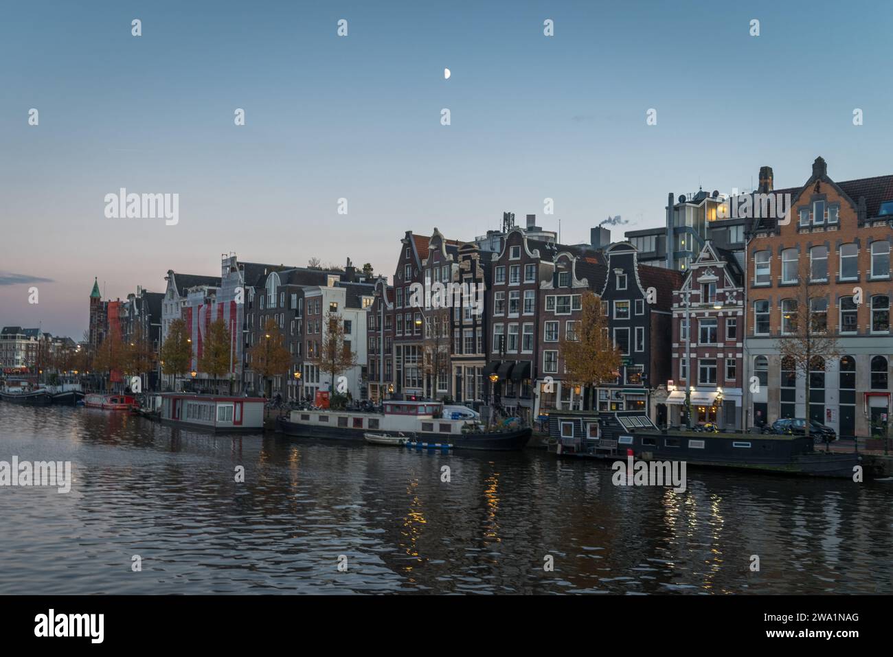 Demi-lune du matin sur le canal d'Amsterdam et les maisons Banque D'Images