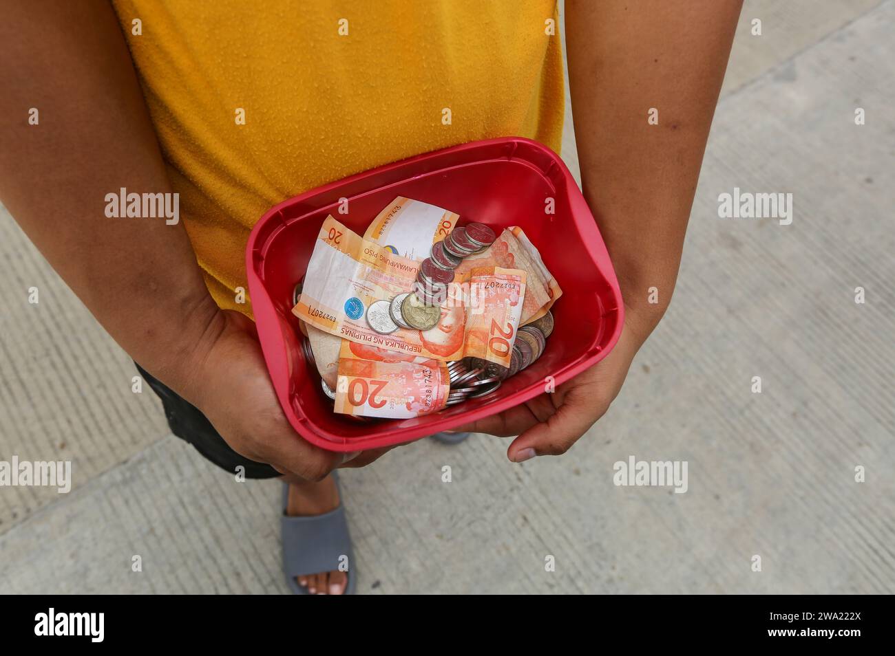 Tiaong, Philippines. 1 janvier 2024 : dans les provinces rurales, les familles pauvres Philippines mettent en place des routes à péage amicales avec une corde et un signe de bonne année. Les voitures, les tricycles ou les piétons sont encouragés à faire des dons de remerciement, généralement seulement quelques pesos, sans obligation, toujours avec le sourire et parfois embellis avec peu de pas de danse. Une tradition qui n’a été pratiquée que dans certaines régions et qui s’est propagée à presque tout le pays depuis les jours difficiles de l’épidémie de COVID 19. Par exemple, sur plus de 1 km, à certains endroits, vous pouvez compter jusqu’à quinze arrêts. Crédit : Kevin Izorce/Alamy Live News Banque D'Images