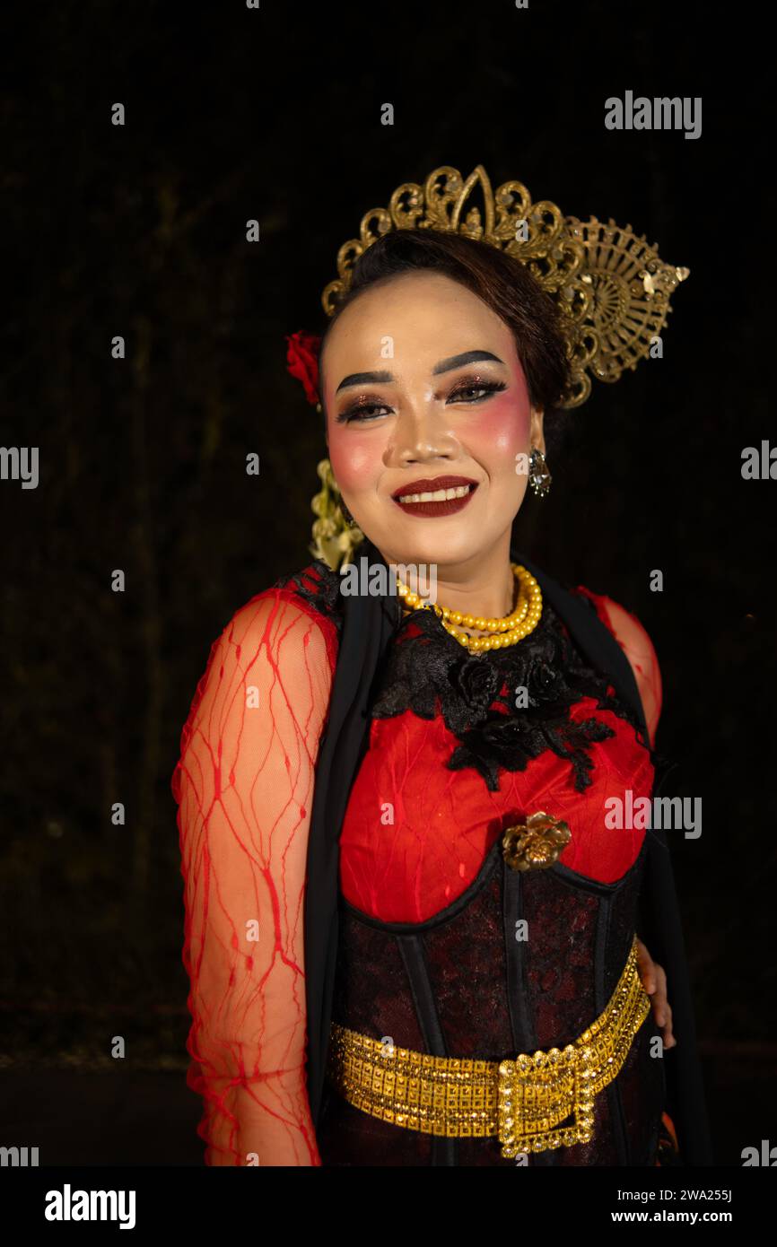 Une danseuse sundanaise portant des bijoux en or qui donne une sensation luxueuse à son apparence sur scène la nuit Banque D'Images