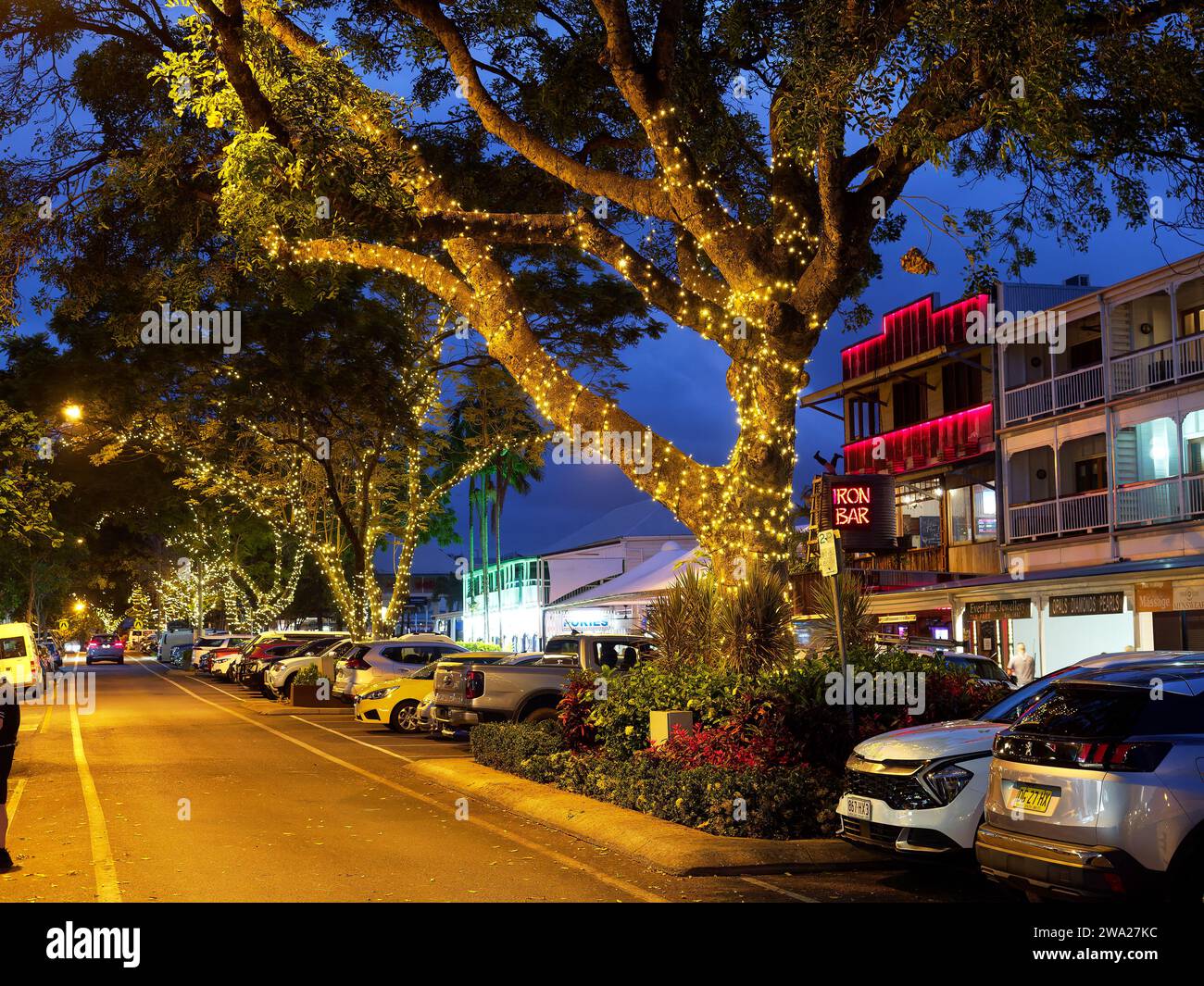 Vue en regardant le long des boutiques, bars et restaurants la nuit sur Macrossan Street, la principale rue commerçante de Port Douglas Queensland Australie Banque D'Images