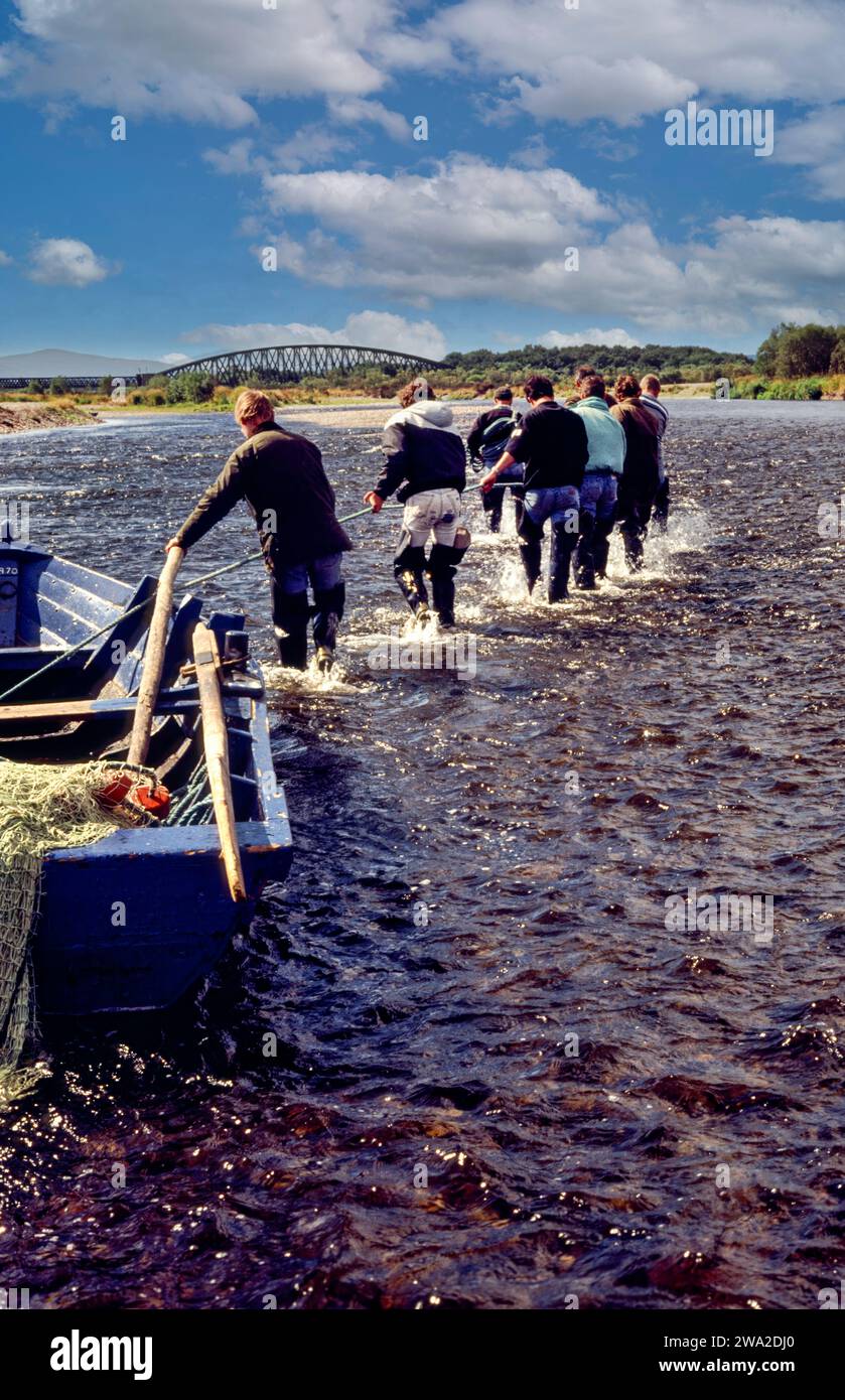 Saumon filet River Spey Écosse pendant les années 1990, l'équipe de pêcheurs tire le bateau à la piscine suivante Banque D'Images