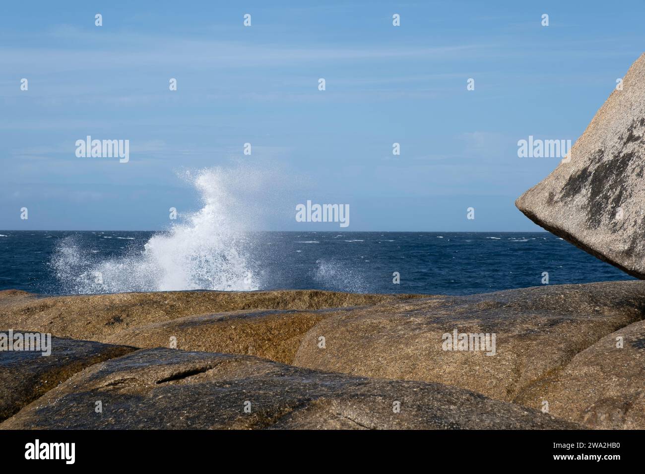 Blowhole dans les roches granitiques de Bicheno Beach, Tasmanie, Australie. Les explosions d'eau venant du trou sont puissantes, l'eau prend de nouvelles formes Banque D'Images