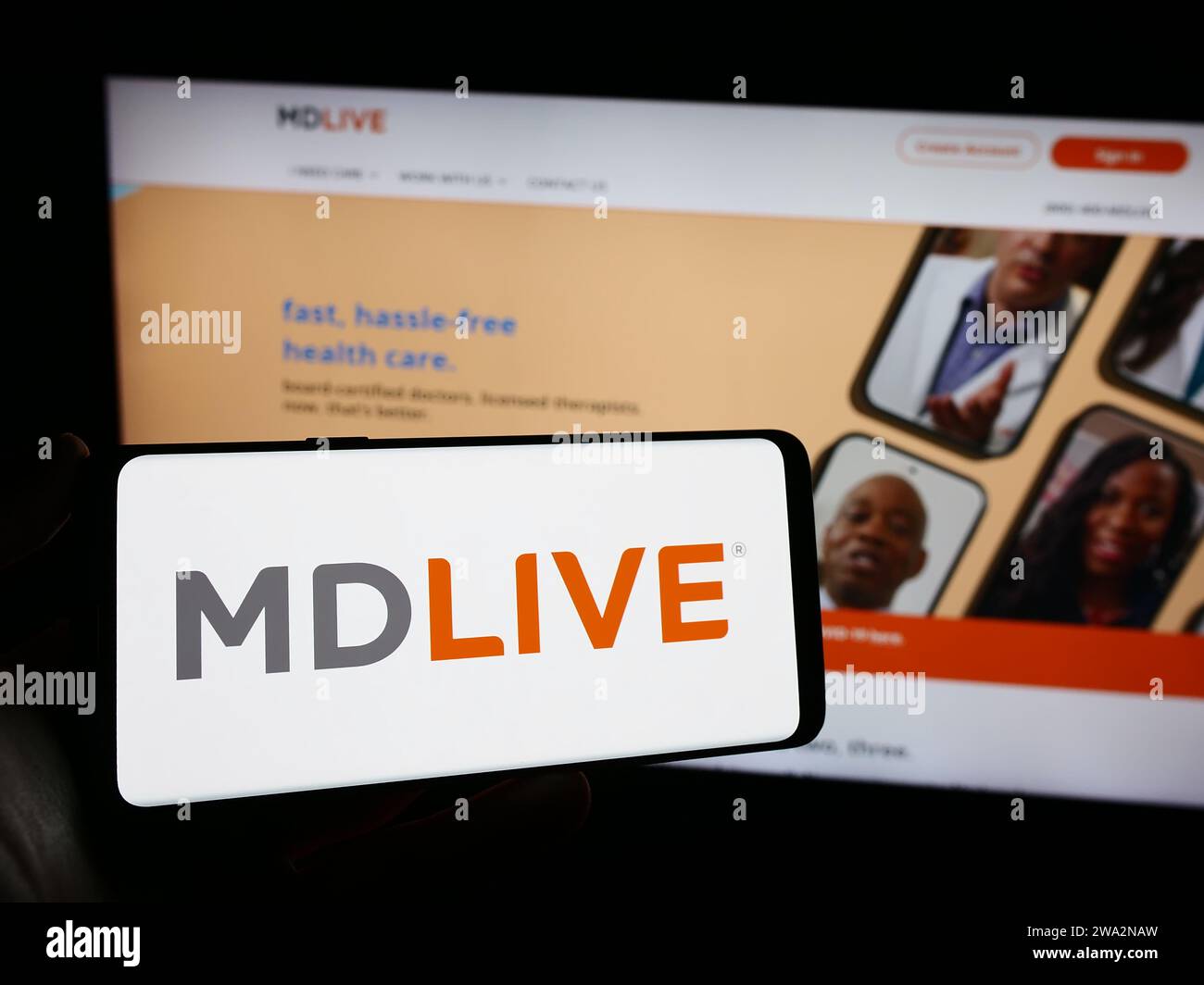 Personne tenant le téléphone mobile avec le logo de la société américaine de services de santé virtuelle MDLIVE en face du site Web. Concentrez-vous sur l'affichage du téléphone. Banque D'Images