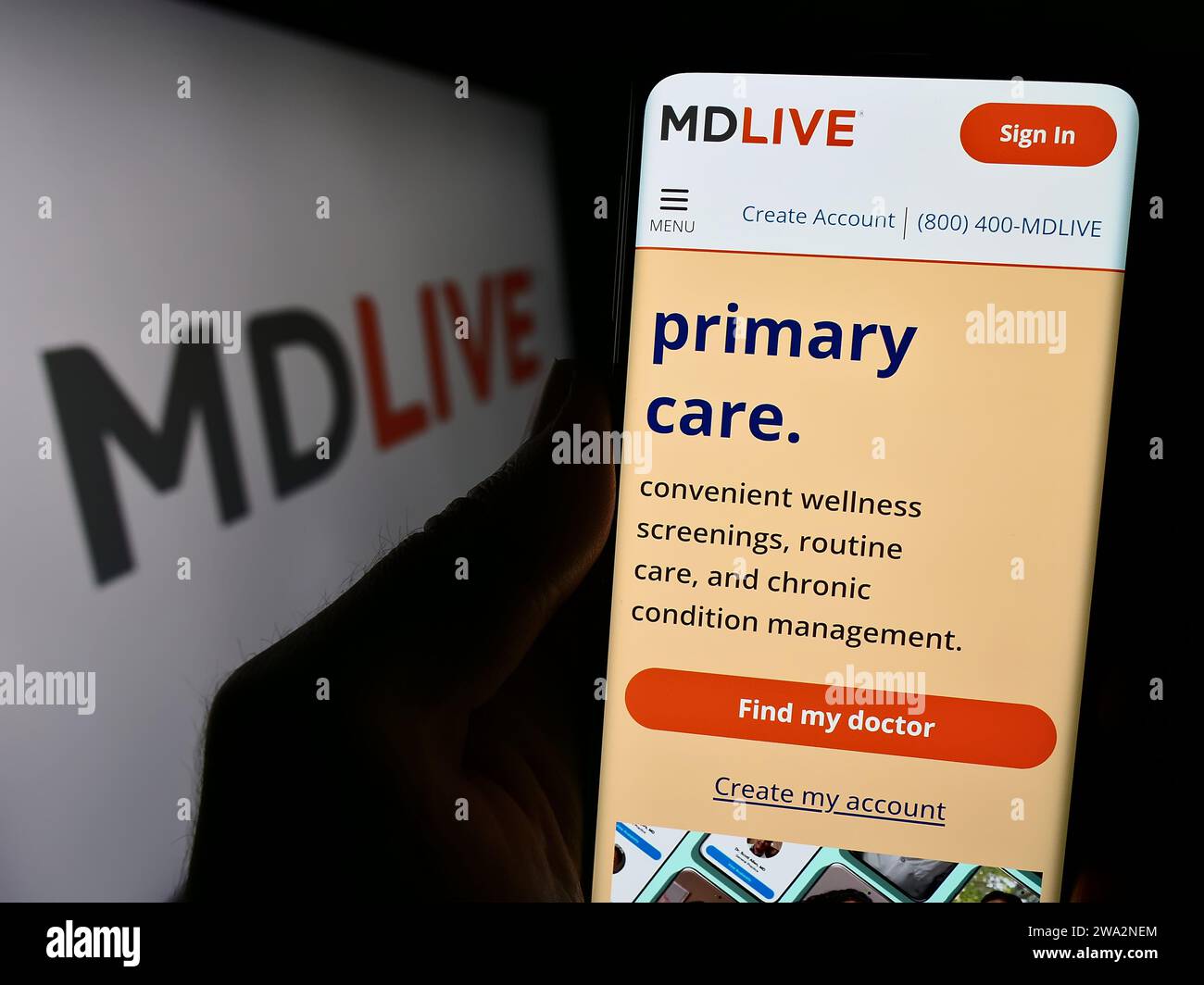 Personne tenant un téléphone portable avec la page Web de la société de services de santé virtuelle américaine MDLIVE devant le logo. Concentrez-vous sur le centre de l'écran du téléphone. Banque D'Images