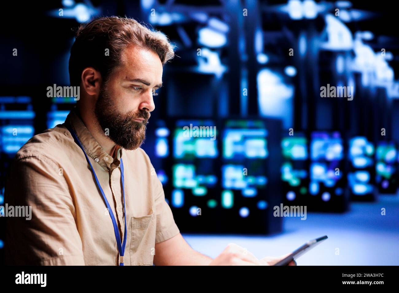 Administrateur système résolution des problèmes de performances dans les armoires de serveur. Expert utilisant une tablette pour identifier les problèmes opérationnels à l'origine du ralentissement de l'infrastructure de l'environnement de travail de haute technologie Banque D'Images