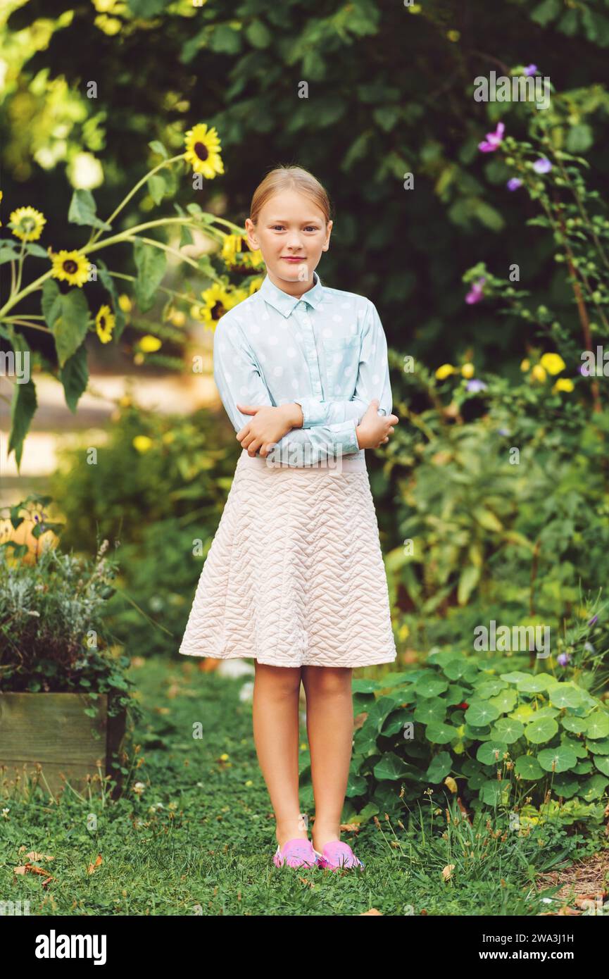 Portrait de mode d'une mignonne petite fille à l'extérieur, portant chemise vert clair et jupe rose Banque D'Images