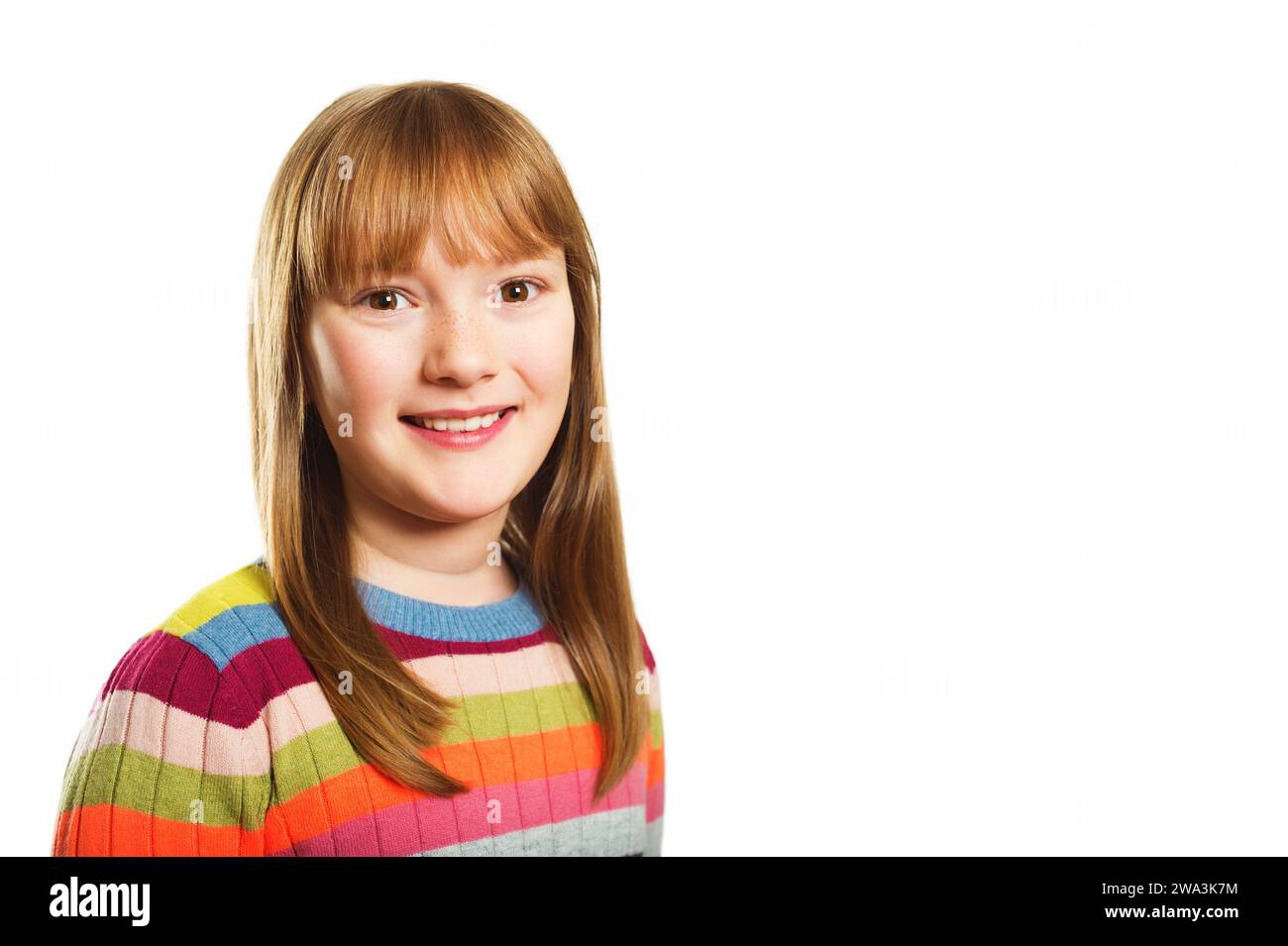 Photo de studio de la jeune petite fille de 9-10 ans, portant un pull coloré, fond blanc Banque D'Images