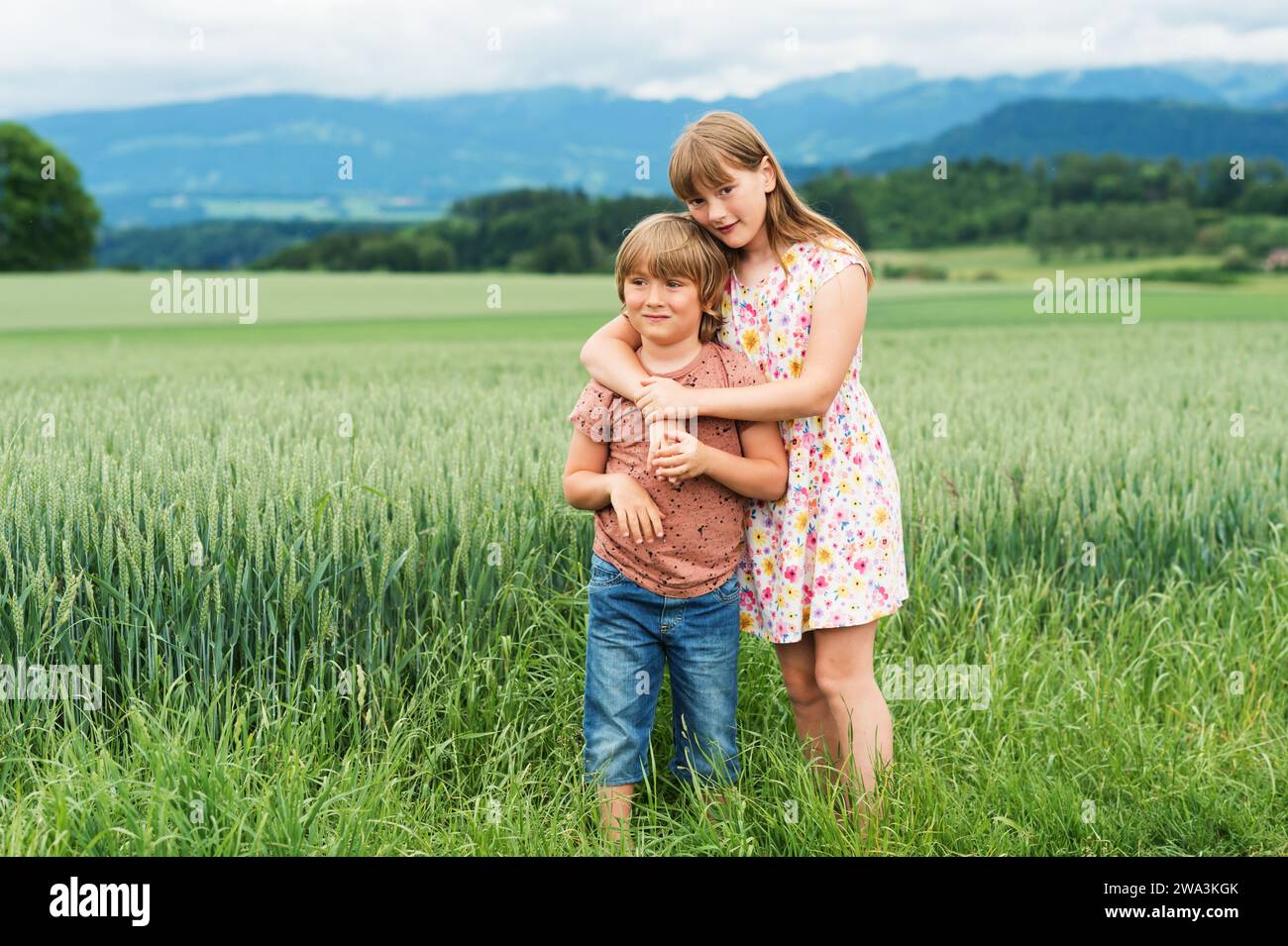 Deux adorables enfants jouant ensemble dans le champ de blé d'été Banque D'Images