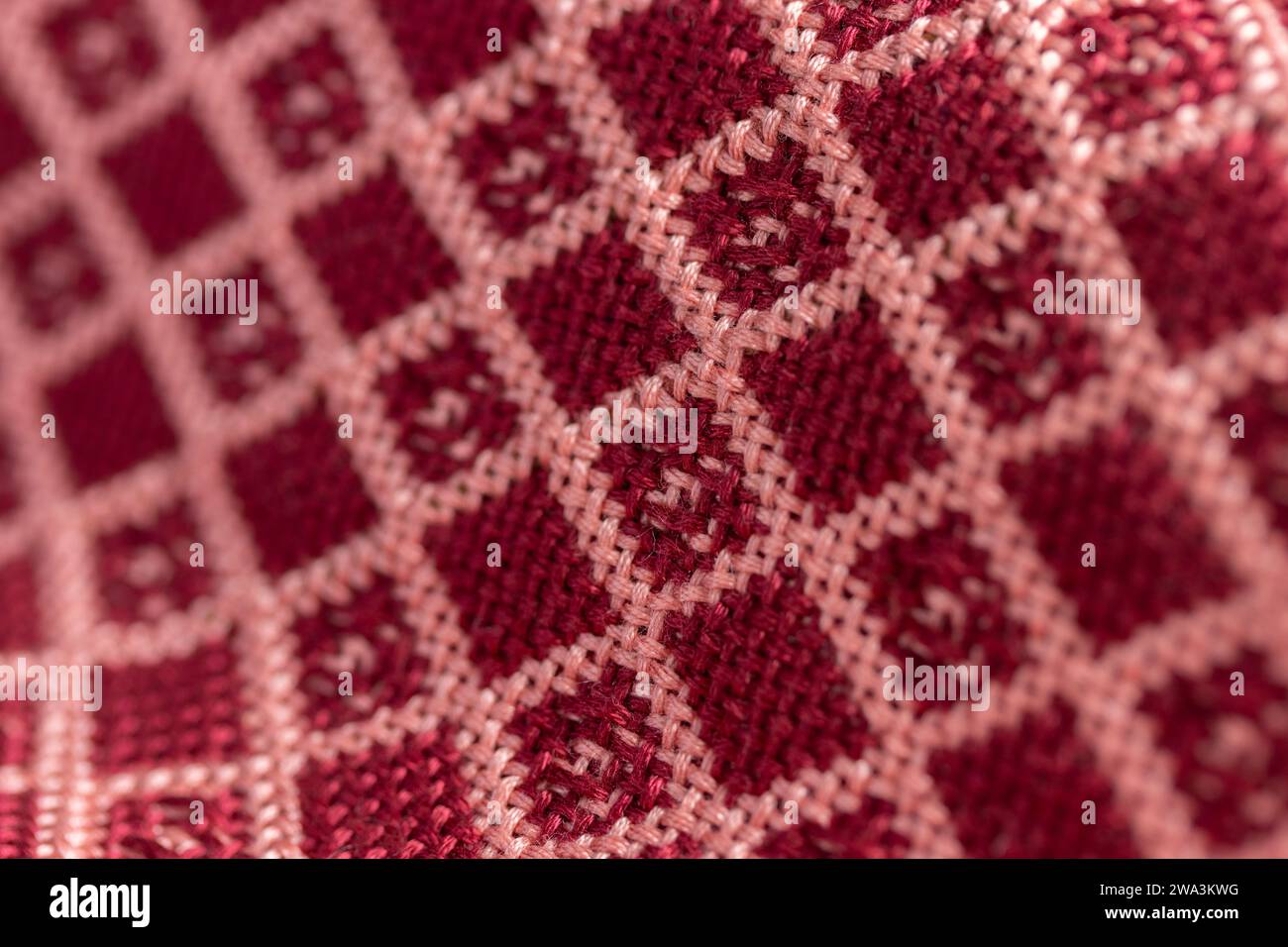 double tissu tissé drapé en rouge et rose géométrique, motif quadrillé en losanges, gros plan macro avec une faible profondeur de champ Banque D'Images