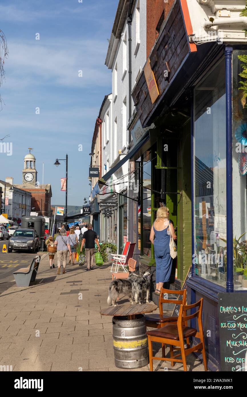Centre-ville de Bridport dans le Dorset Angleterre, gens sur la rue est et femme promenant son chien, temps ensoleillé septembre, Royaume-Uni, 2023 Banque D'Images