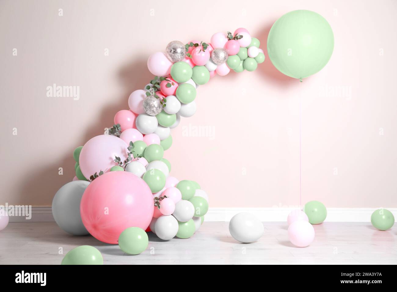 Guirlande de ballons près du mur beige dans la chambre. Décor festif Banque D'Images