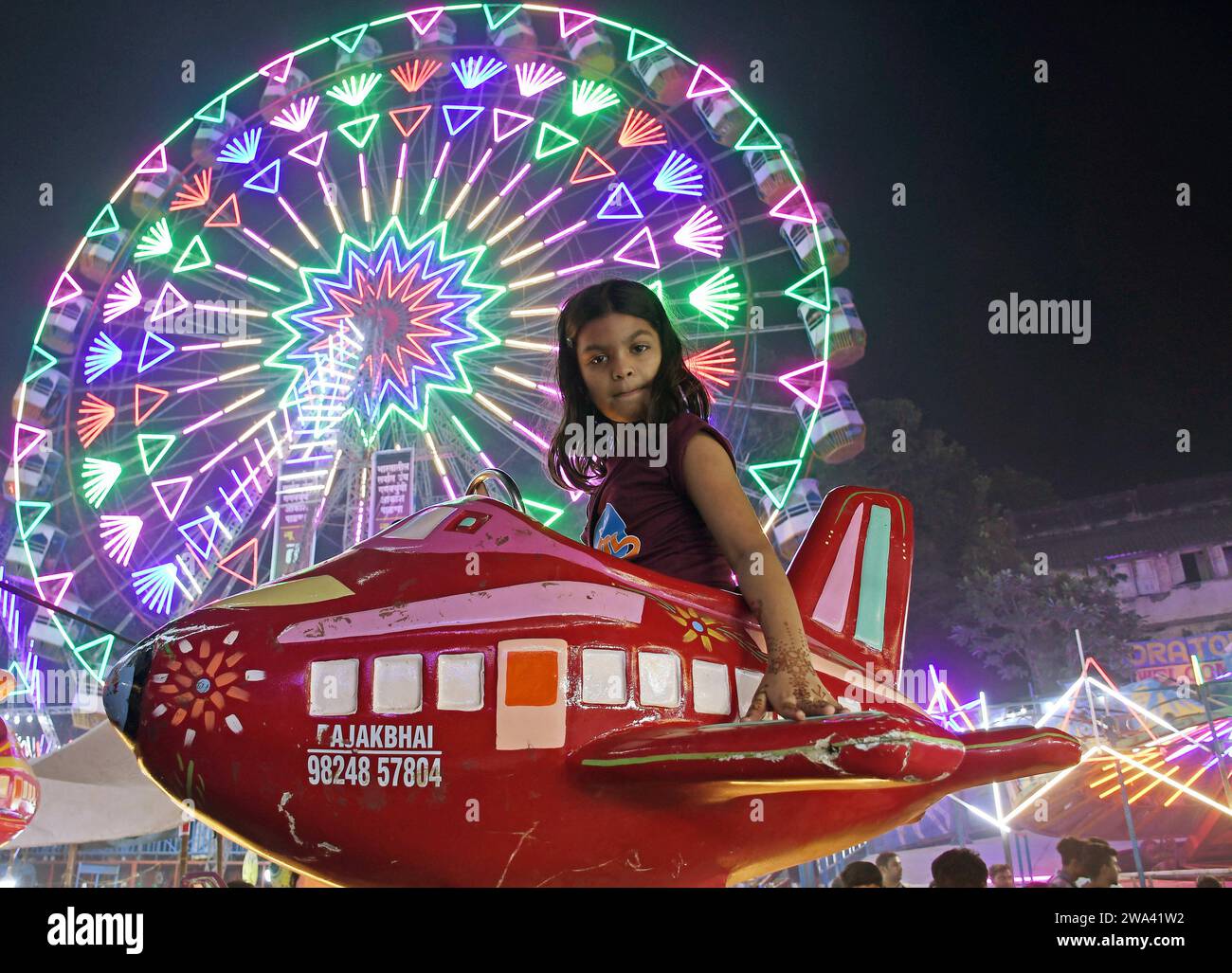 Mumbai, Maharashtra, Inde. 29 décembre 2023. Une fille aime le tour d'amusement d'avion à Mahim (zone dans le sud de Mumbai) foire à Mumbai. Une foire annuelle est organisée chaque année pour honorer Pir Makhdoom Shah (saint spirituel musulman) vénéré par les musulmans et les non-musulmans. L'événement de dix jours aura lieu du 27 décembre 2023 au 7 janvier 2024 offrant une variété de manèges alimentaires et d'attractions. (Image de crédit : © Ashish Vaishnav/SOPA Images via ZUMA Press Wire) USAGE ÉDITORIAL SEULEMENT! Non destiné à UN USAGE commercial ! Banque D'Images