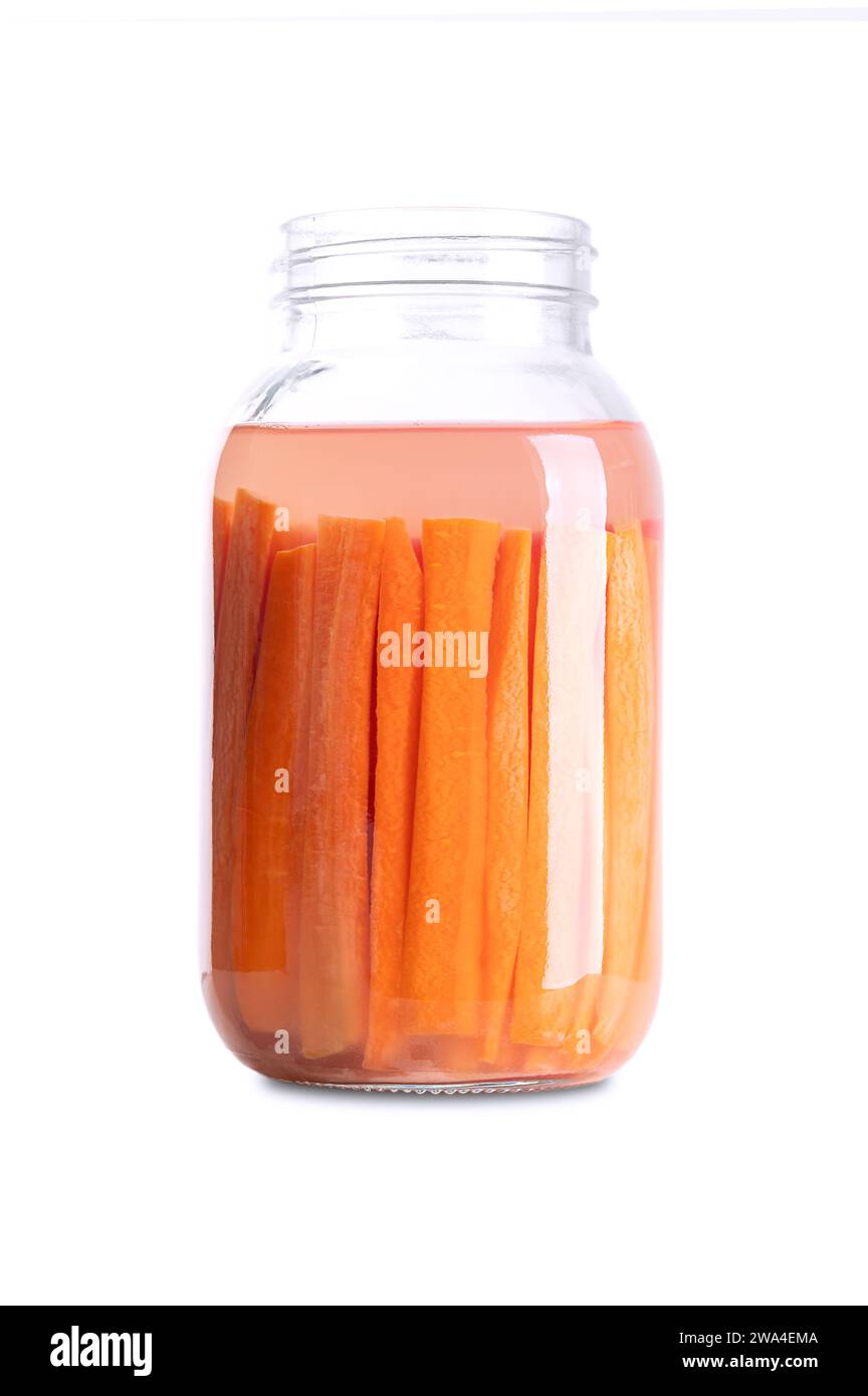 Bâtonnets de carottes, carottes fermentées maison, dans un bocal en verre. Carottes coupées en bâtonnets et fermentées par des bactéries lactiques. Banque D'Images