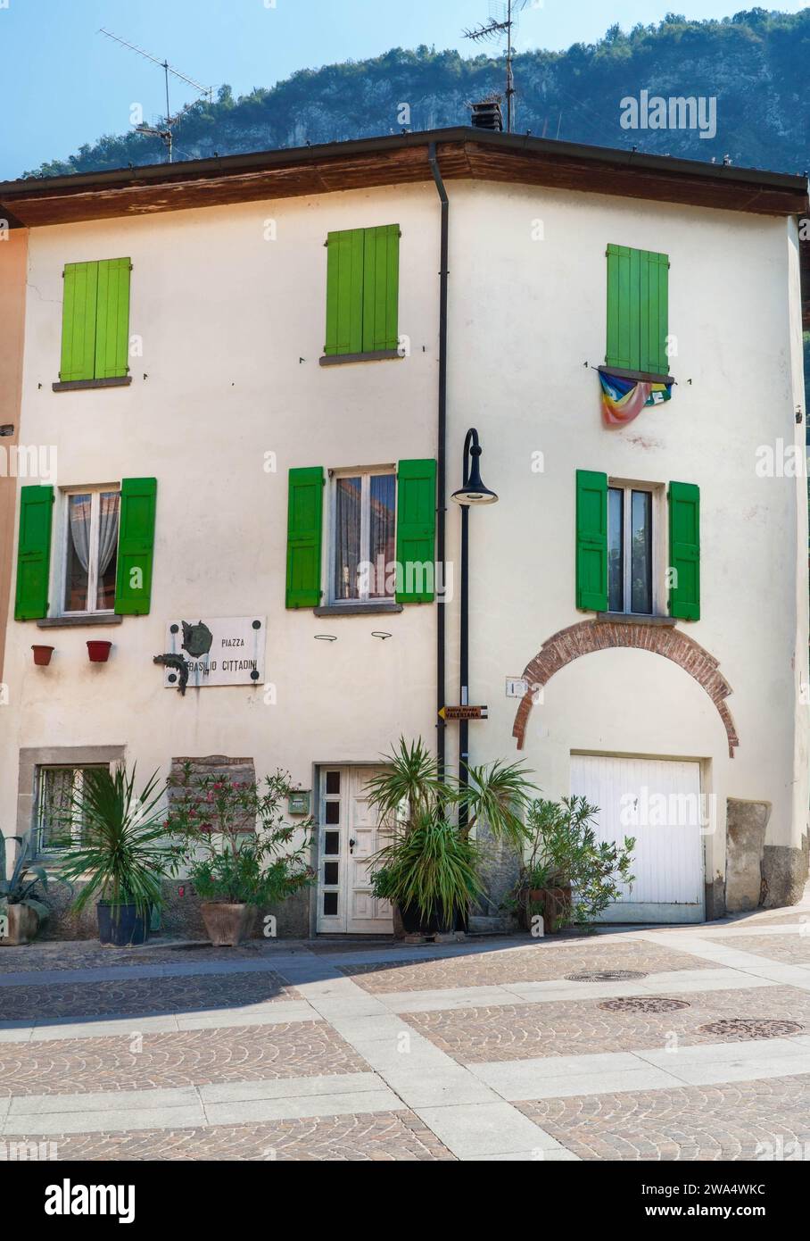 Propriété résidentielle avec volets verts sur la Piazza Basilio Cittadini, Pilzone, lac Iseo Lombardie Italie. Septembre 2023 Banque D'Images