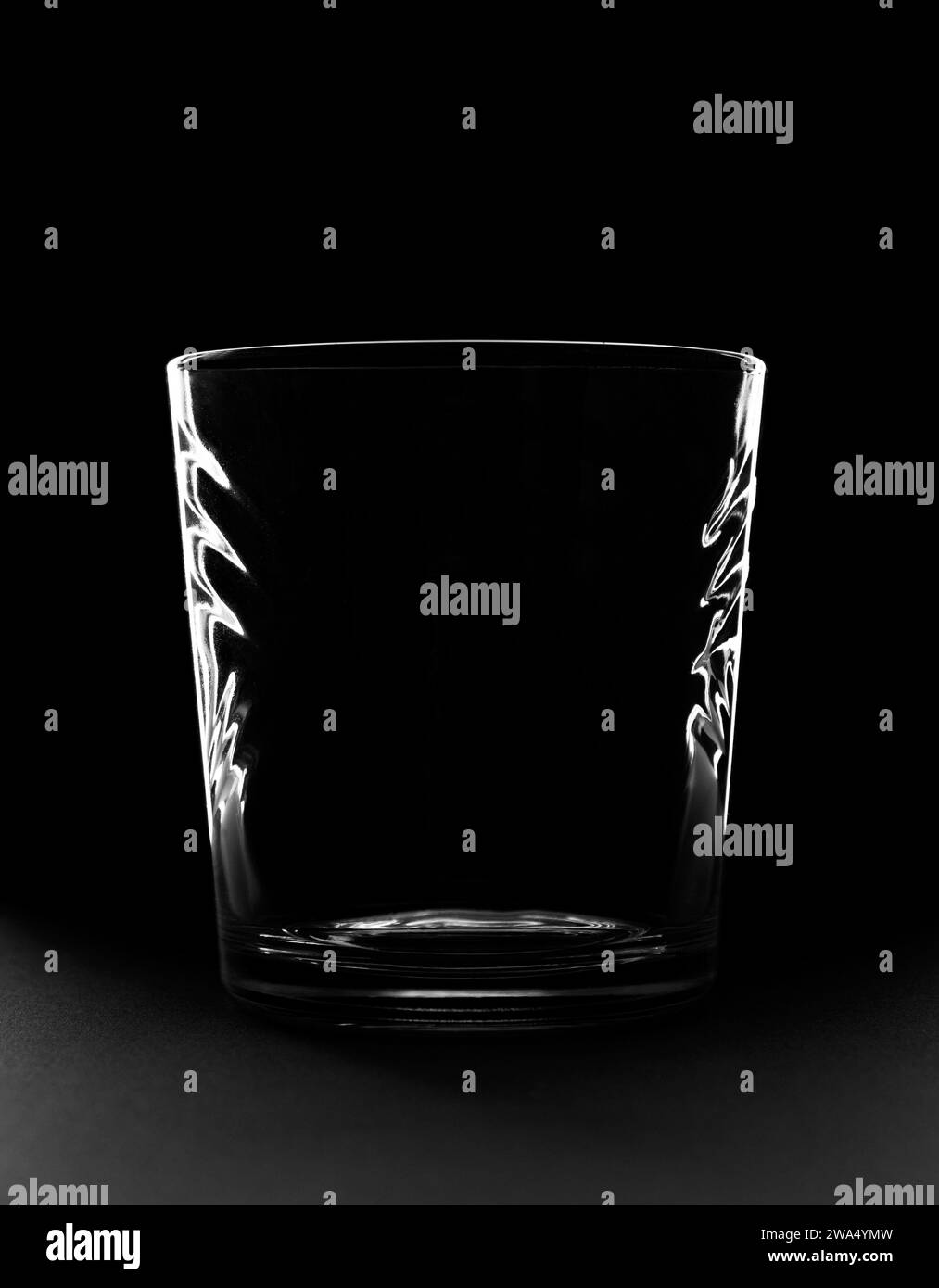 Versez de l'eau dans un verre sur fond noir. Banque D'Images