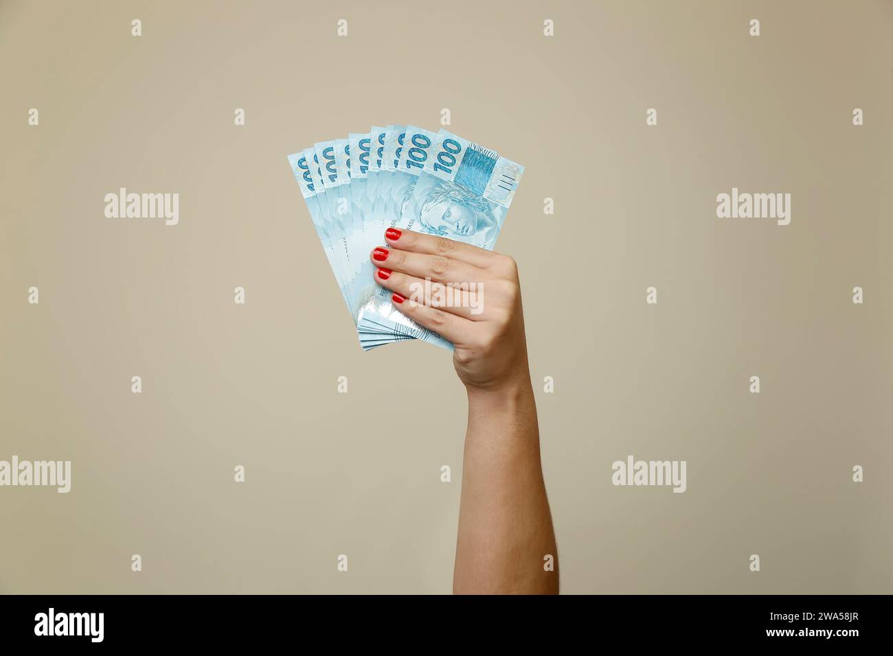 Plusieurs centaines de factures réelles - argent du Brésil dans une main de womans avec des ongles rouges Banque D'Images