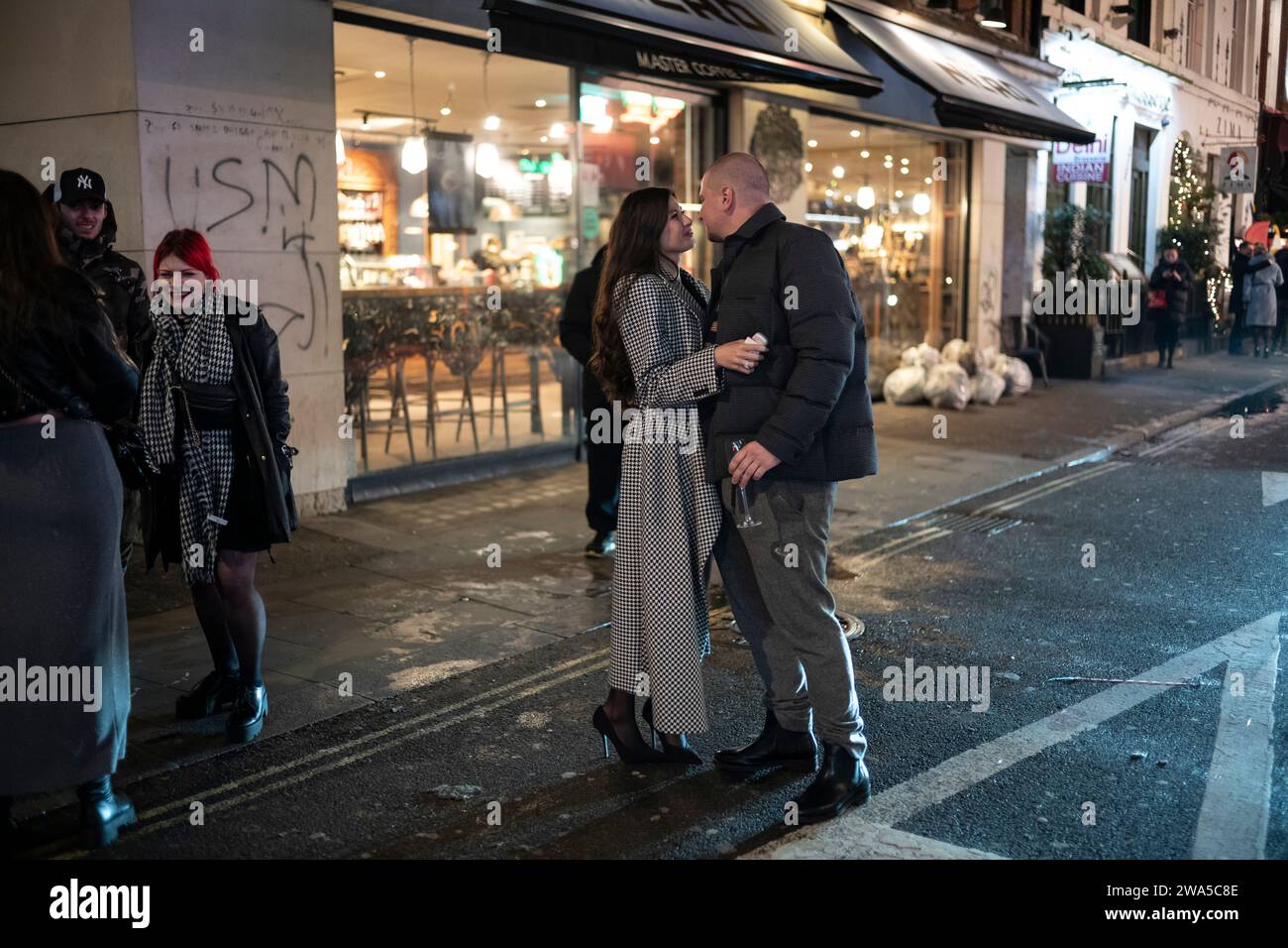 Les gens apprécient l'atmosphère de fête de la Saint-Sylvestre tandis qu'ils sont parmi la foule à Soho, le quartier West End de la capitale, Londres, Angleterre, Royaume-Uni. Banque D'Images