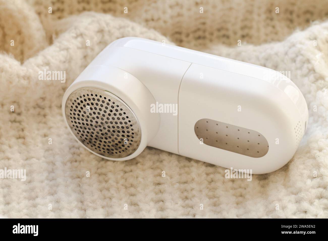 Rasoir moderne en tissu blanc et pull en laine léger, gros plan Banque D'Images