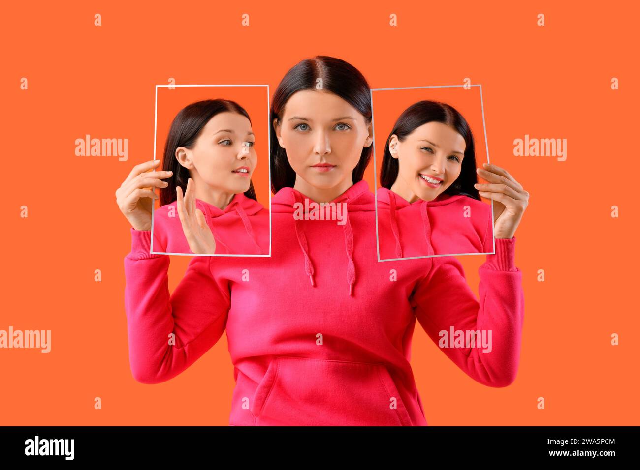Jeune femme tenant des affiches avec des émotions différentes sur fond orange Banque D'Images