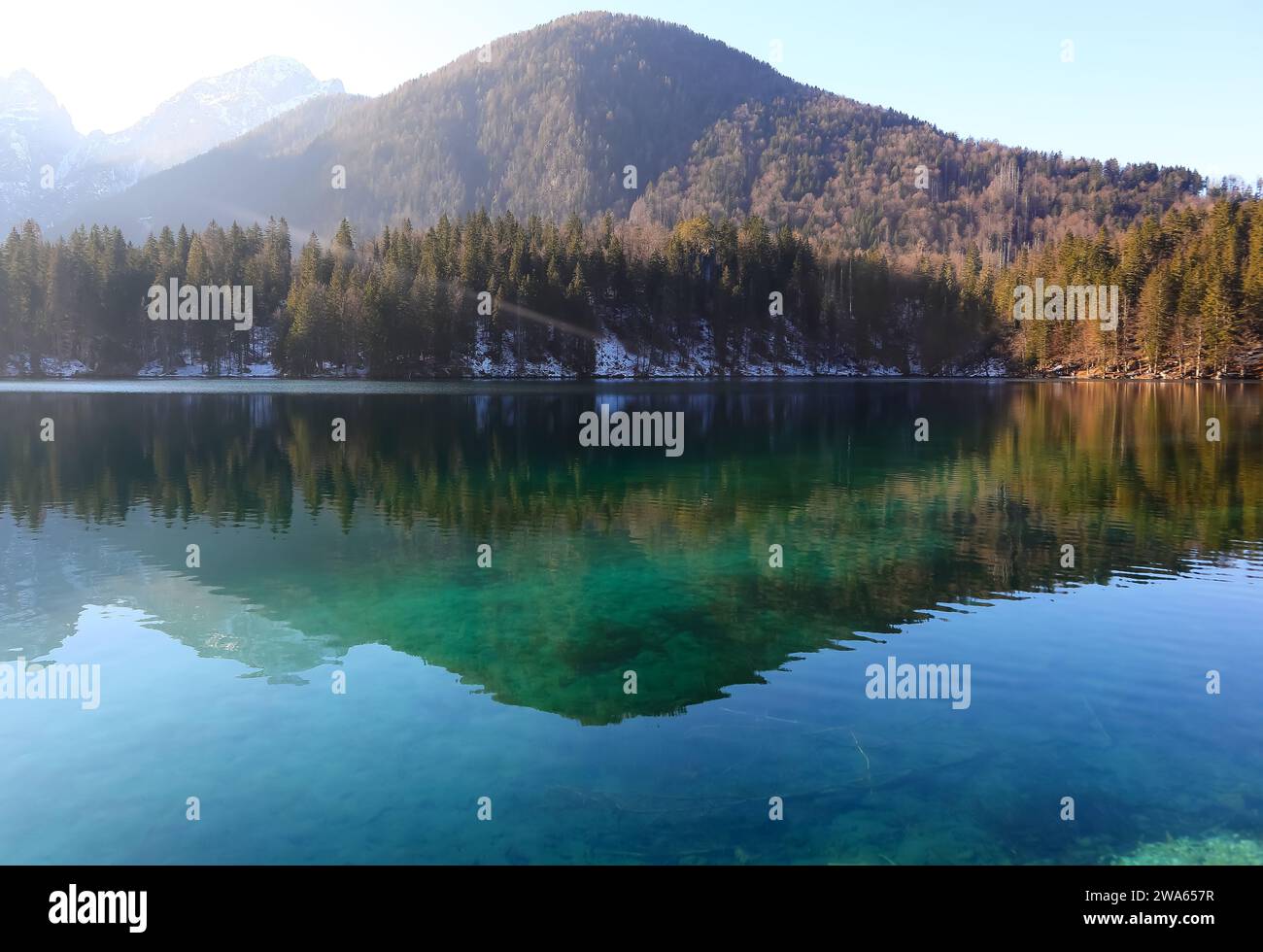 Panorama de montagne enchanteur avec les Alpes italiennes en hiver et le lac d'origine glaciaire dans lequel les arbres se reflètent Banque D'Images