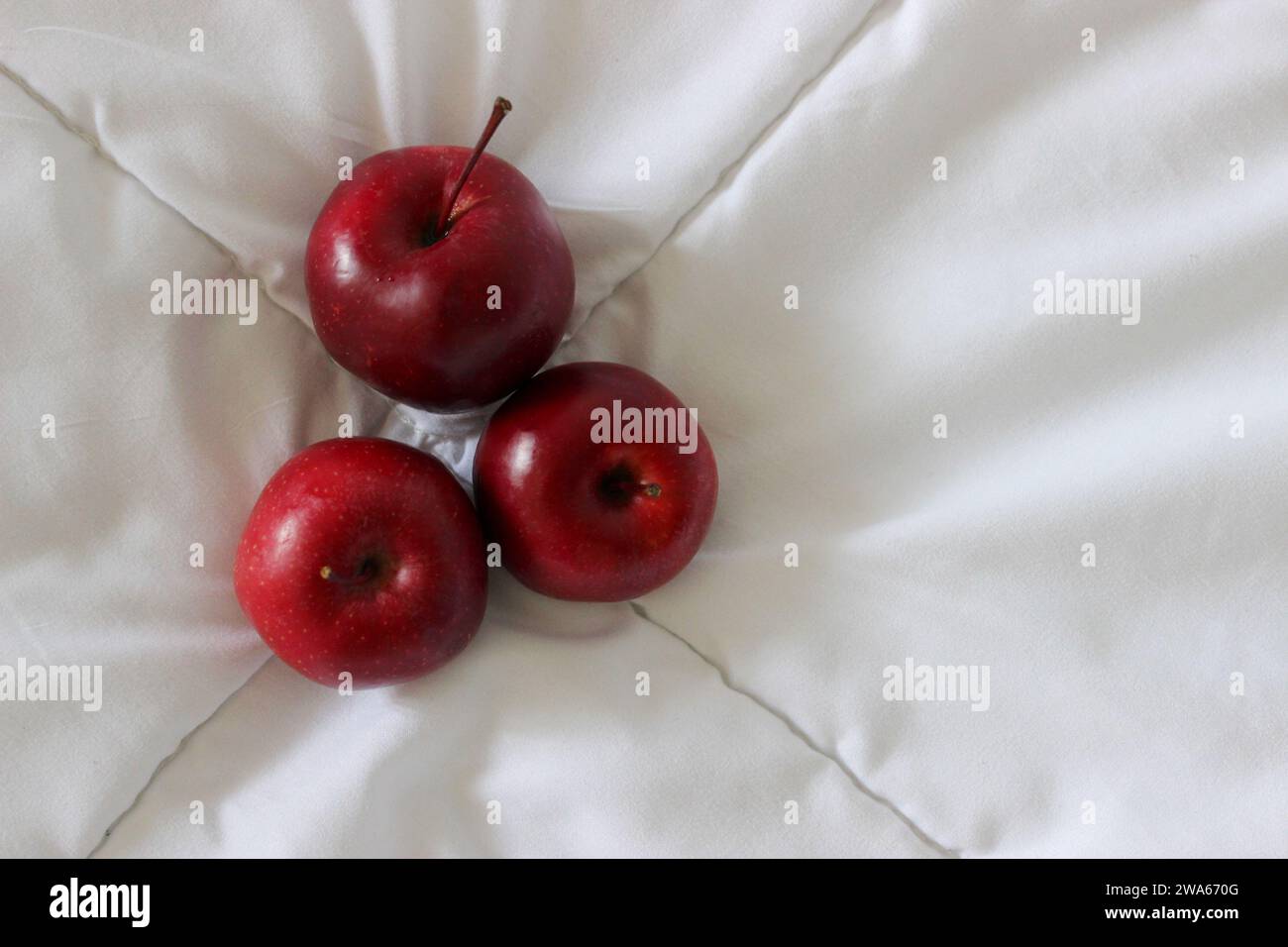 Trois pommes juteuses rouges sur Un tissu blanc Voir photo stock Banque D'Images