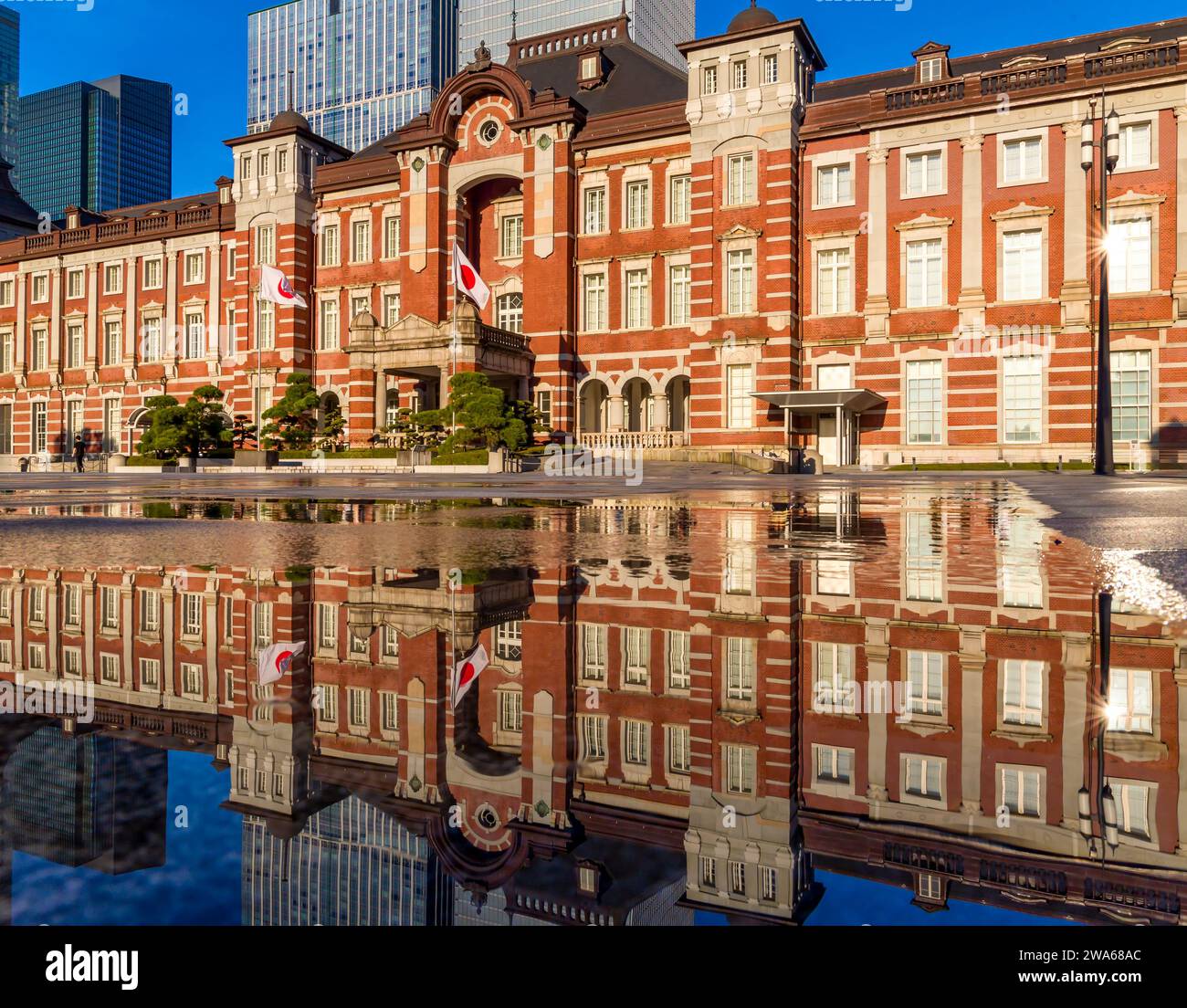 Beau reflet de la gare de Tokyo en briques rouges dans de l'eau pulvérisée pour refroidir le chemin en plein été Banque D'Images