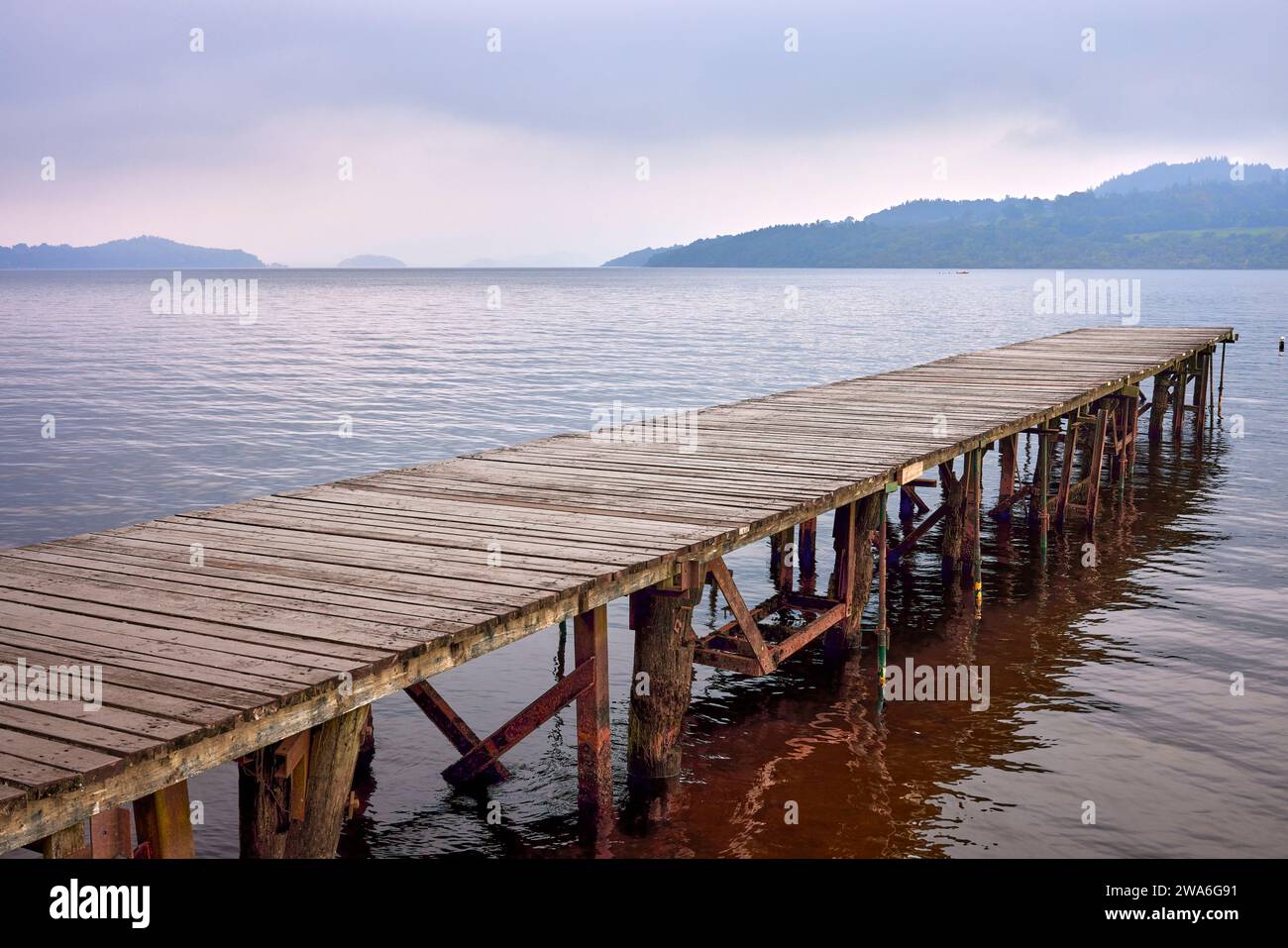 Sur le Loch Lomond, une jetée déserte en bois s'étend au-dessus de l'eau. Écosse. ROYAUME-UNI Banque D'Images