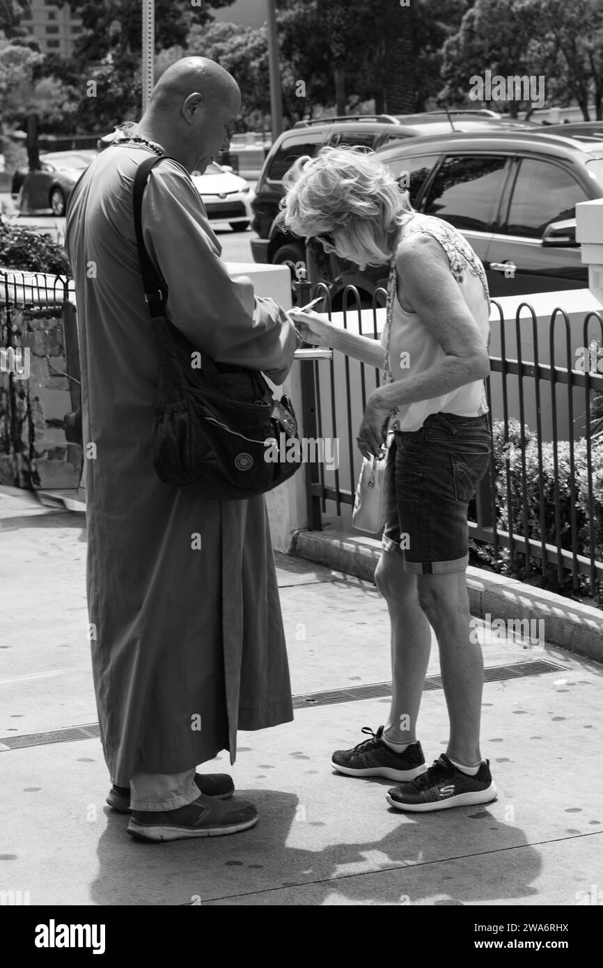 Un touriste parle avec un bouddhiste et signe un appel à la paix.. Las Vegas, capitale mondiale du divertissement, Nevada, États-Unis Banque D'Images