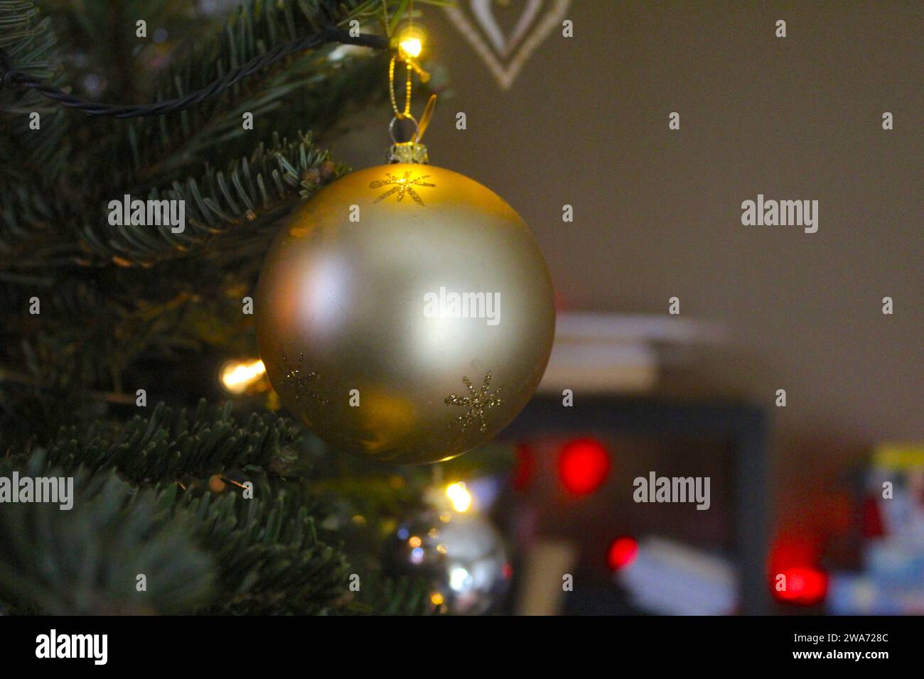 Gros plan d'un ornement de décoration de Noël suspendu à une branche d'arbre de Noël. Banque D'Images