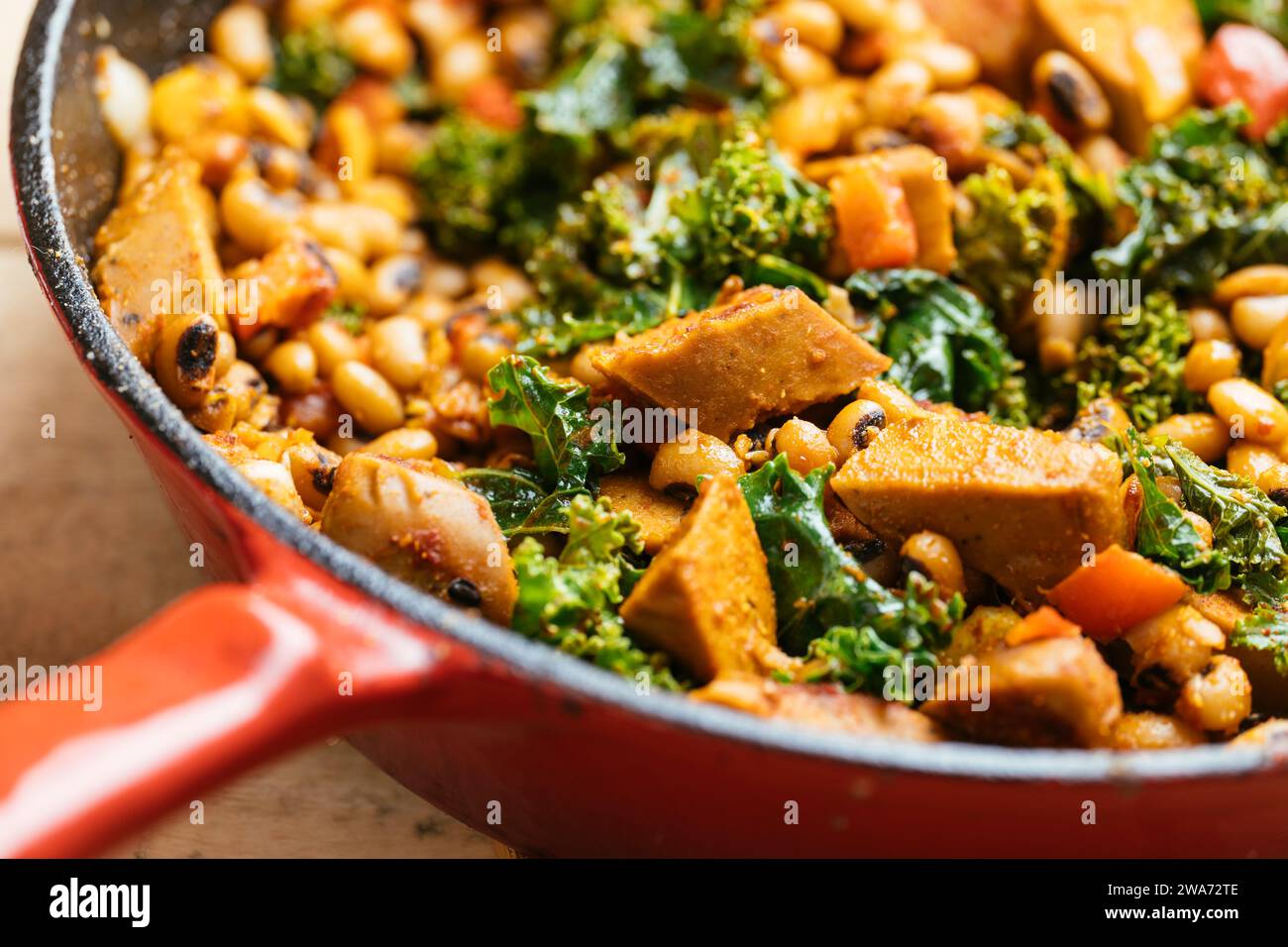 Hoppin' John- pois aux yeux noirs avec wursts végétaliens dans une poêle en fonte. Banque D'Images