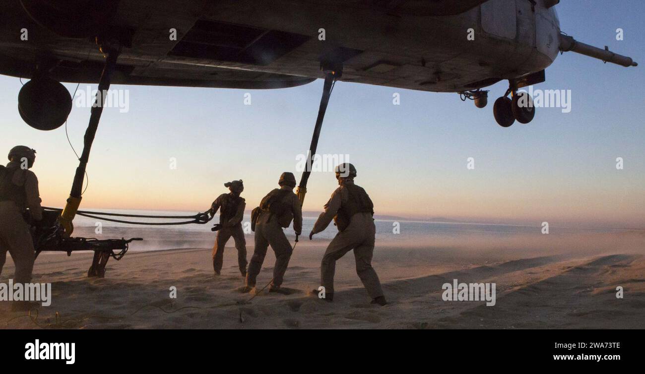 Forces militaires AMÉRICAINES. 151029WC184-006 PINHEIRO DA CRUZ, PRAIA DA RAPOSA, Portugal – les Marines américains avec l’équipe de soutien aux hélicoptères, le détachement de soutien à l’atterrissage avec la 26e unité expéditionnaire des Marines, embarquent à bord du navire de transport amphibie USS Arlington (LPD 24) préparez-vous à attacher une élingue reliée à une remorque M105 à un crochet de levage d'un CH-53E Super Stallion avec Marine Medium Tilt rotor Squadron 162 (VMM-162),26th MEU, embarqué à bord de l'USS Arlington, planant au-dessus de vous pendant un exercice d'entraînement au levage externe à Pinheiro Da Cruz, Praia Da Raposa Beach, Portugal, 22 octobre 2015, d Banque D'Images