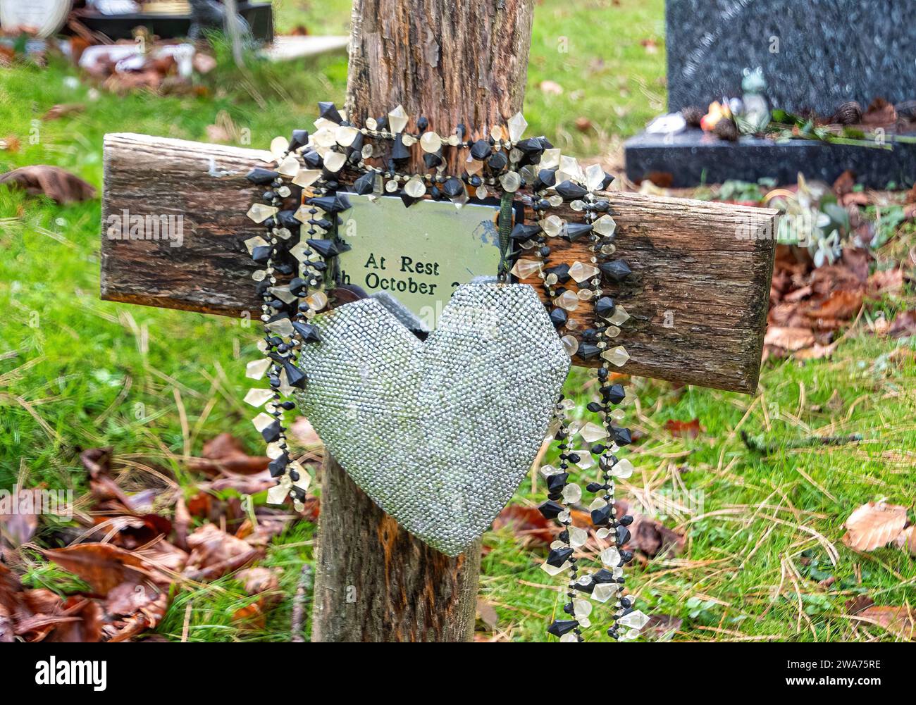 Tombe catholique dans un cimetière marqué d'une croix en bois avec des perles de chapelet, Angleterre, Royaume-Uni. Religion catholique romaine Banque D'Images