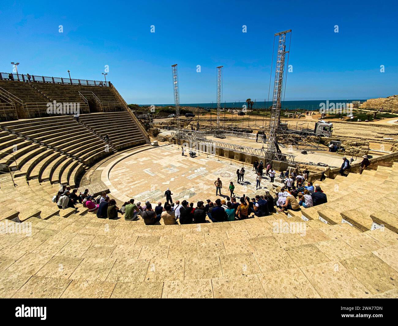 Spectacle balnéaire : personnes assises dans un amphithéâtre au bord de la mer Méditerranée à Cesarea Maritima Banque D'Images