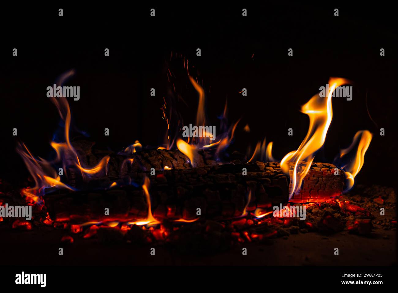 Brûler du bois de chauffage dans Cozy Hearth : les flammes scintillent dans la cheminée rustique Banque D'Images