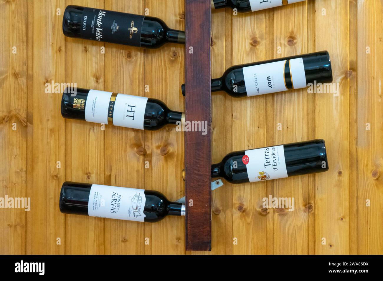 Évora, Alentejo, Portugal. 26 novembre 2022. Présentation de bouteilles de vin de l'Alentejo sur support mural dans un restaurant rustique. Banque D'Images