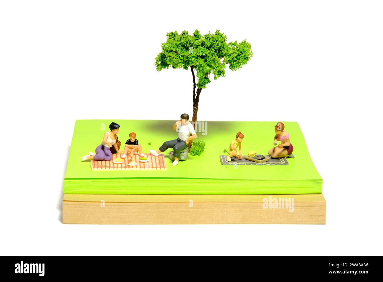 Photographie de figurine miniature créative de personnes. Installation de notes autocollantes. Pique-nique en famille au jardin public, parc en vacances d'été. Banque D'Images