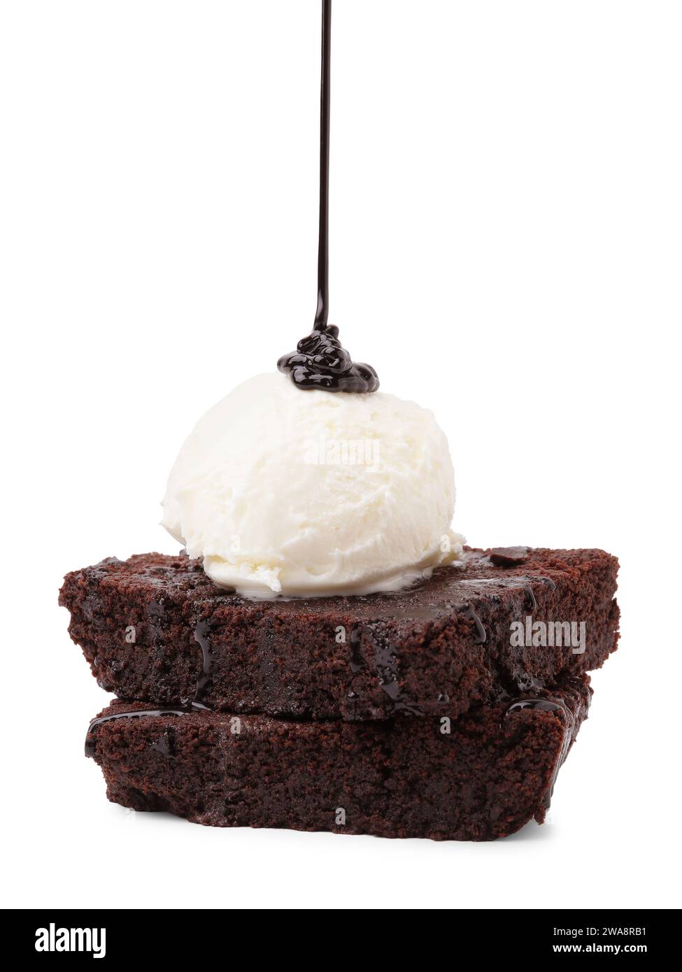 Verser de la sauce au chocolat sur de délicieux brownies avec de la crème glacée isolée sur blanc Banque D'Images