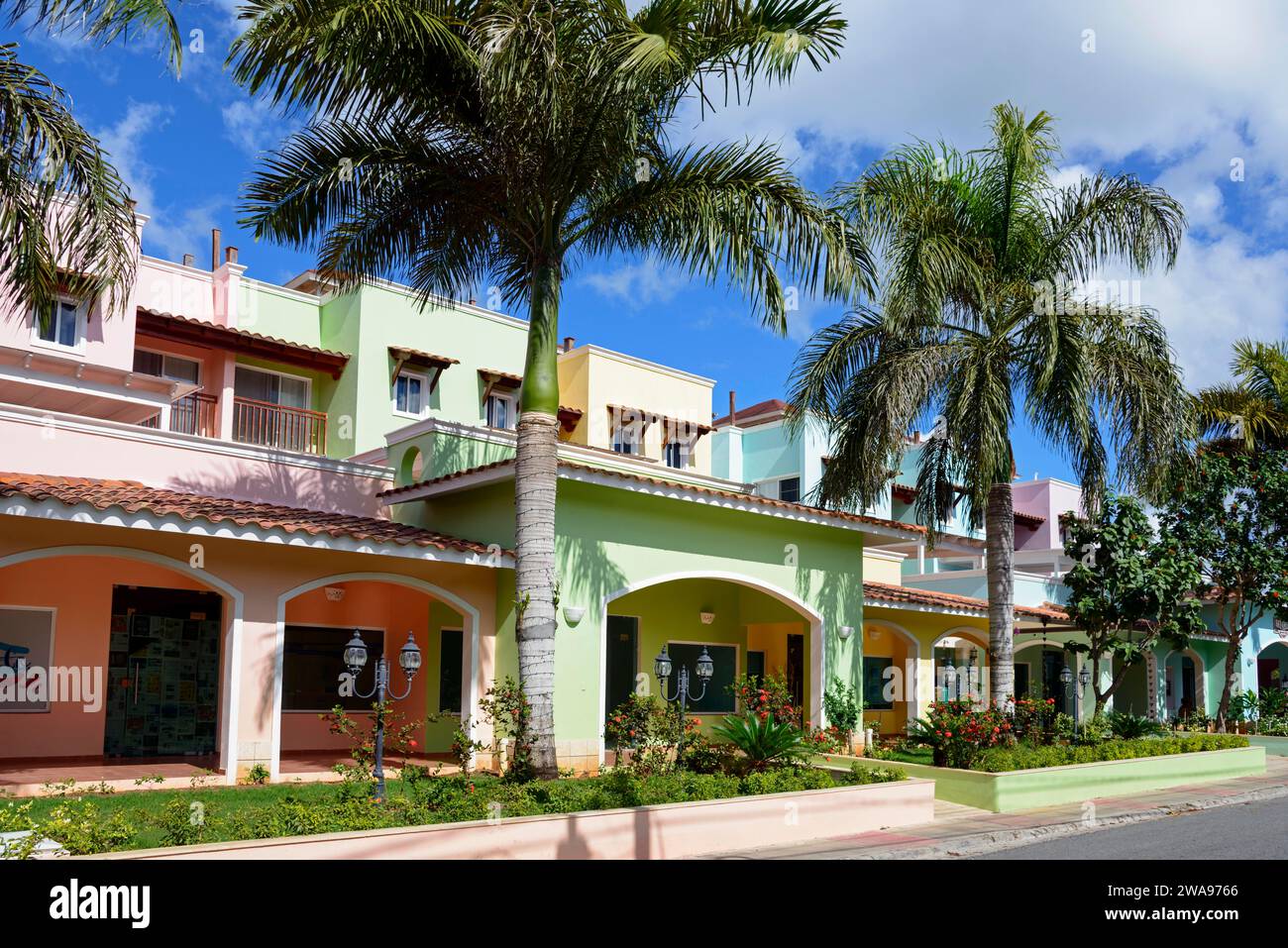 Des maisons colorées sous un ciel bleu avec des palmiers créent une atmosphère tropicale et détendue, Bayahibe, République Dominicaine, Hispaniola, Caraïbes, Ameri Banque D'Images