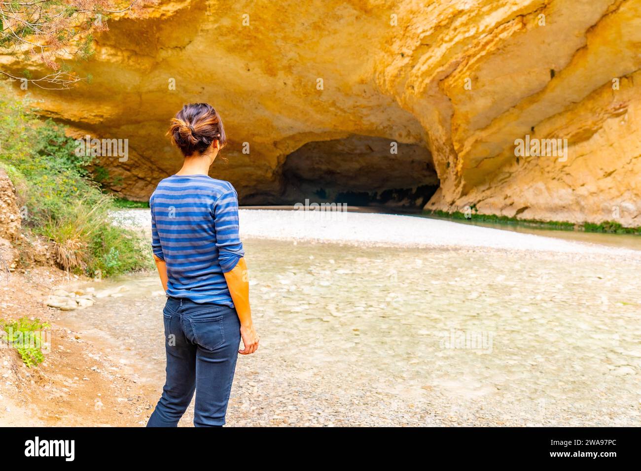 Femme visitant la grotte sur le chemin de promenade de la rivière Vero à Alquezar. Huesca Pyrénées Banque D'Images