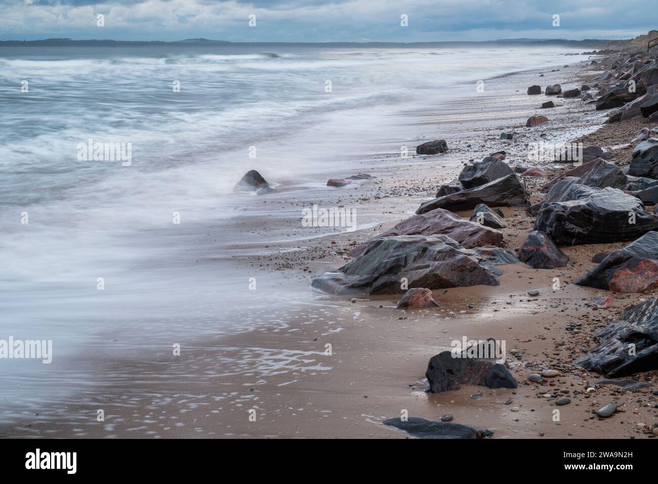 Rochers et mer sur la plage de Findhorn en hiver. Findhorn, Morayshire Écosse. Exposition longue Banque D'Images