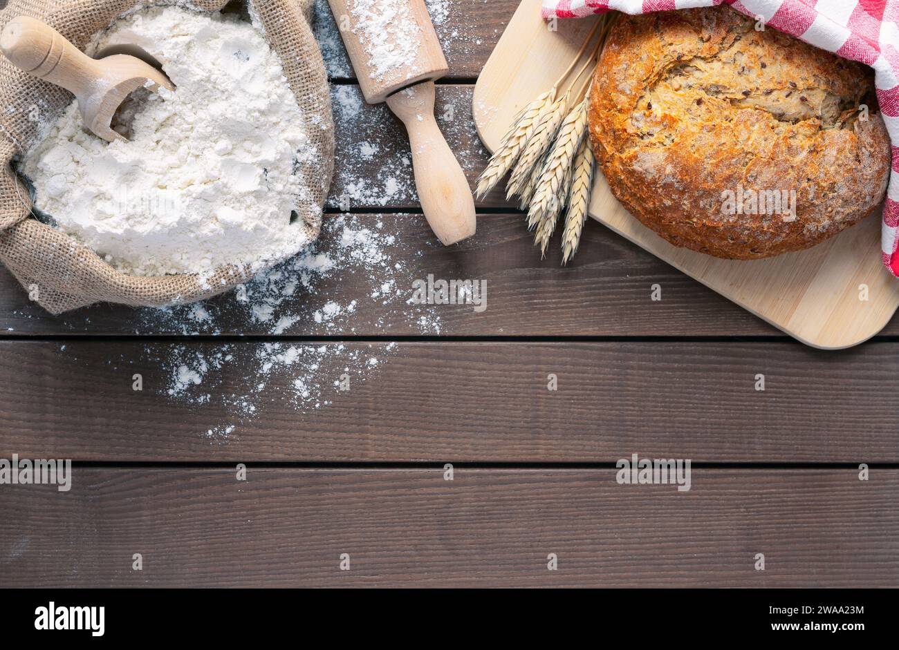 pain sur planche à découper, farine et rouleau à pâtisserie sur fond en bois, espace de copie Banque D'Images