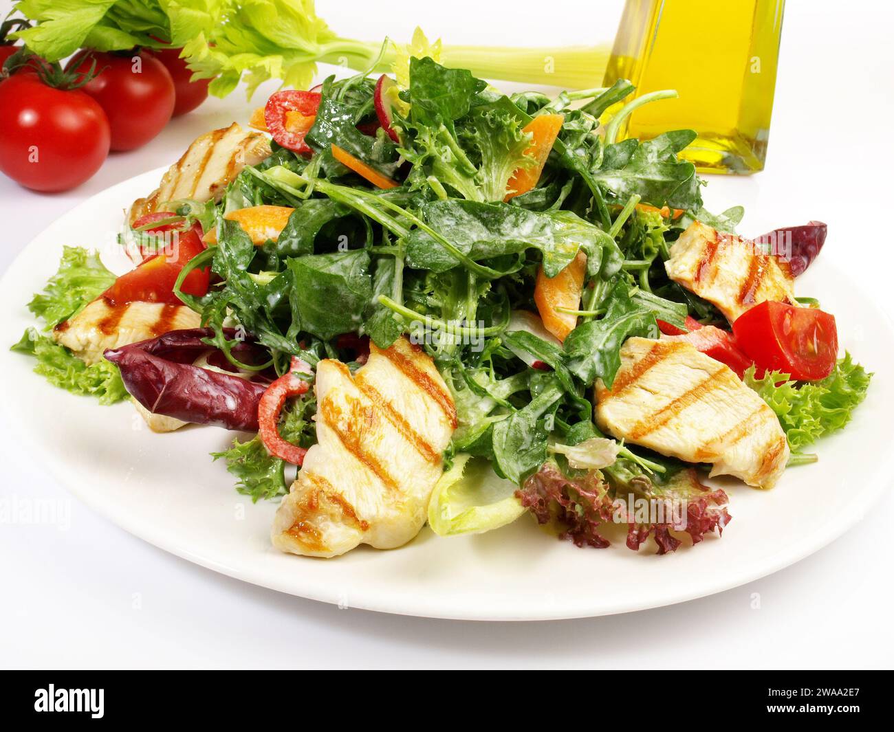 Salade mixte avec épinards et roquette et poulet grillé Isolé sur fond blanc Banque D'Images