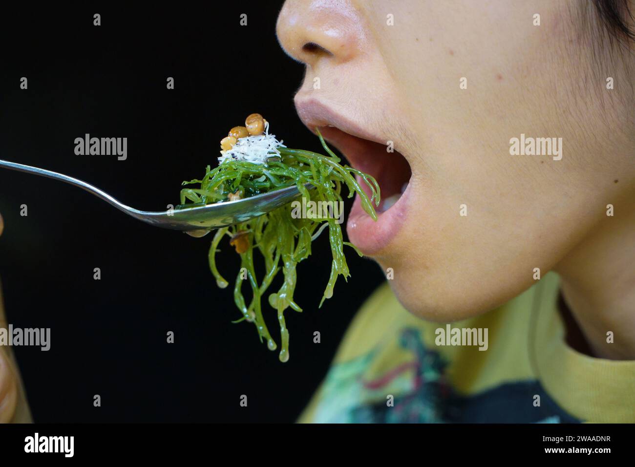 Nusa Penida, Bali-septembre 04 2021 : une photo de gros plan de bouche manger les algues sur une cuillère. A Bali, c'est appelé bulung Banque D'Images