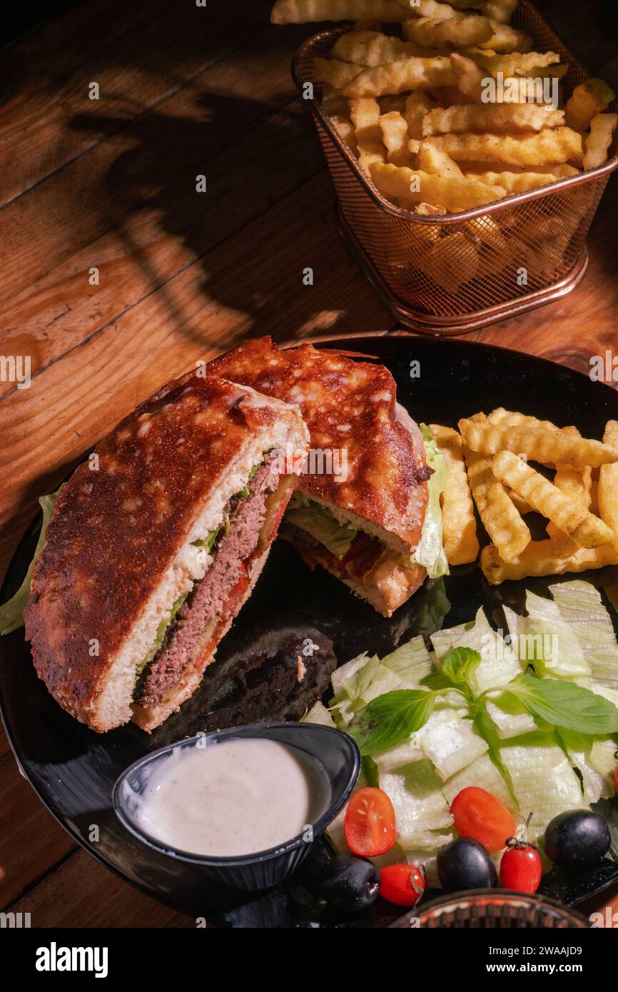 Polyvalent et satisfaisant : que vous le dégustiez pour le déjeuner, le dîner ou pour une collation tard dans la nuit, notre Burger est la nourriture réconfortante ultime qui vous conviendra Banque D'Images