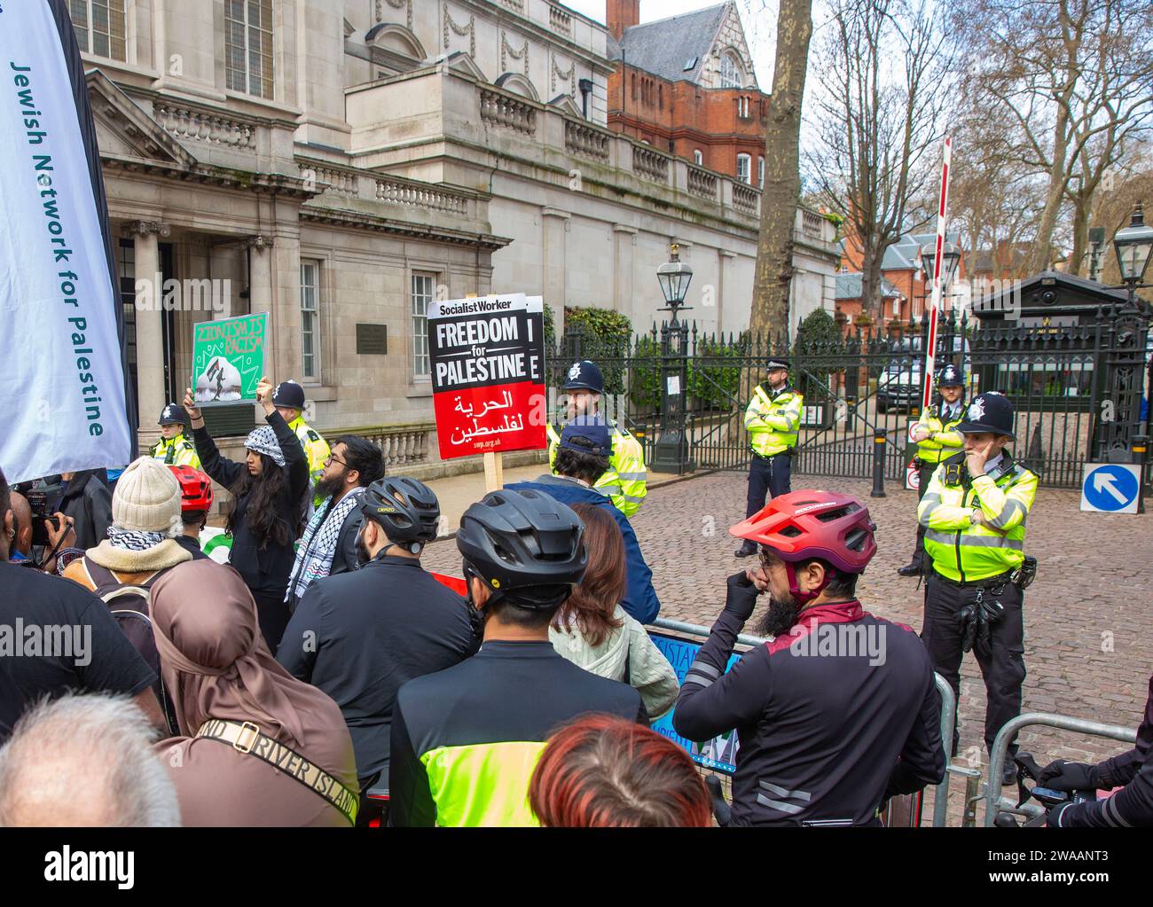 Les manifestants pro-palestiniens se rassemblent avec des drapeaux et des pancartes lors d'une manifestation devant les portes de l'ambassade d'Israël à Londres. Banque D'Images