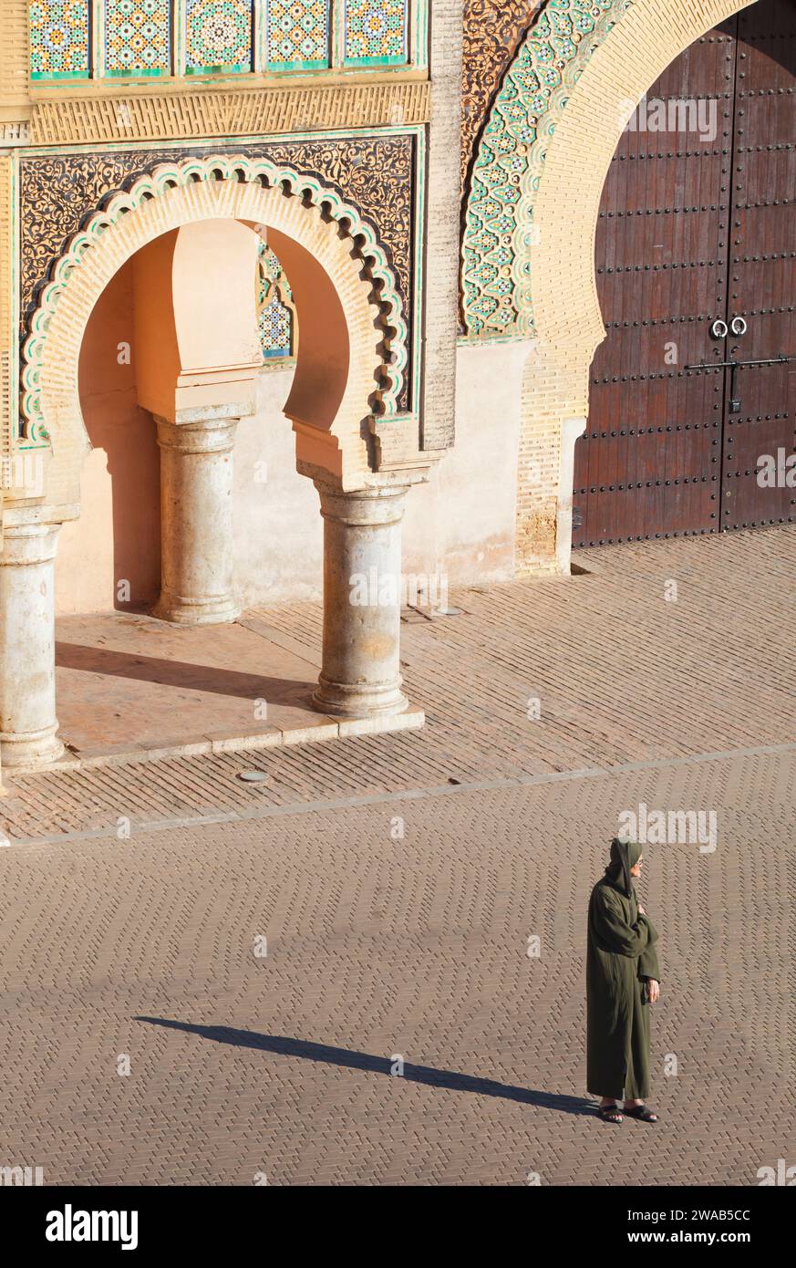 Un homme âgé avec une djellaba traditionnelle devant la porte Bab Mansour, Meknès, Maroc. Banque D'Images