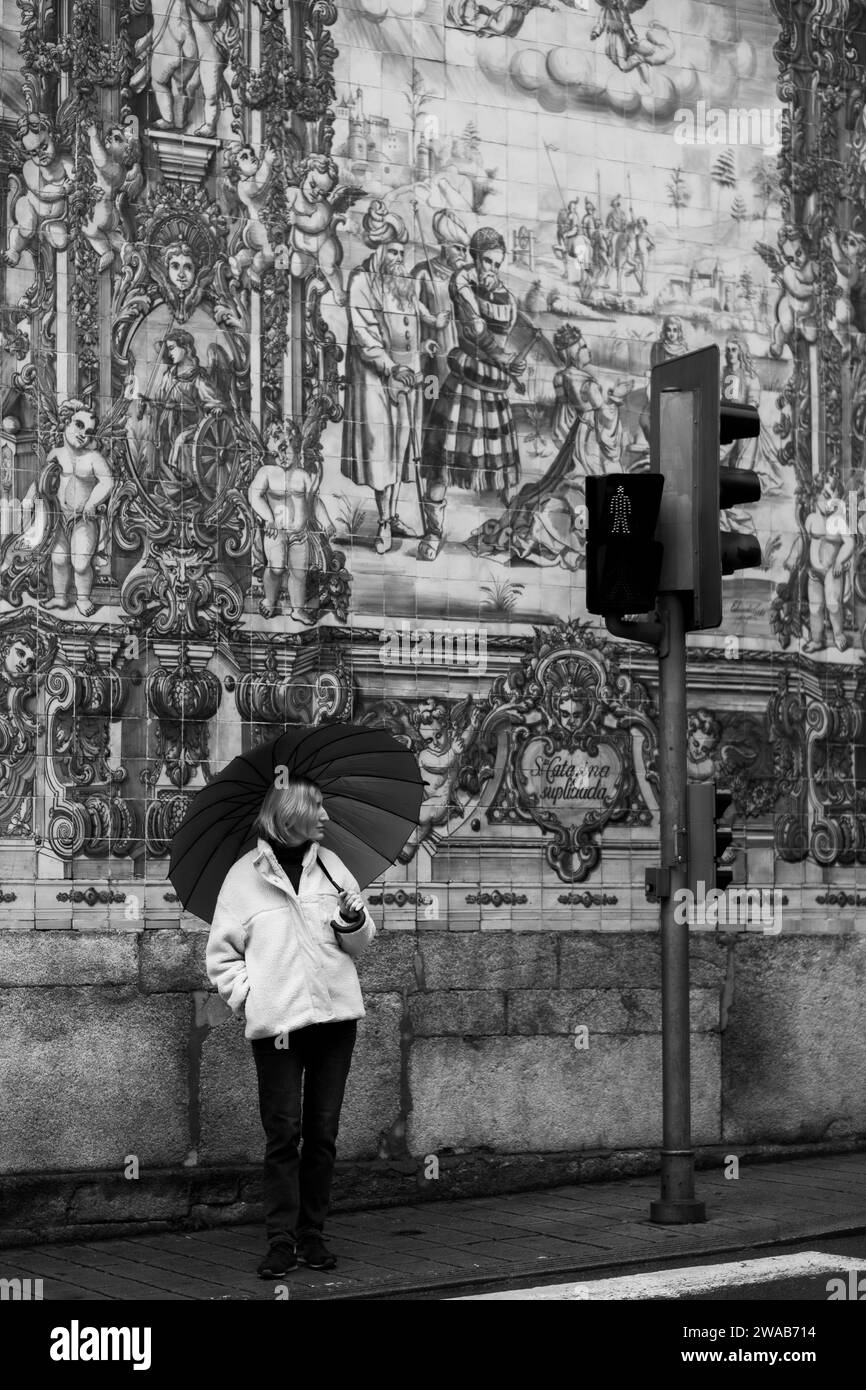 Une femme avec un parapluie dans une rue à Porto, Portugal. Photo noir et blanc. Banque D'Images