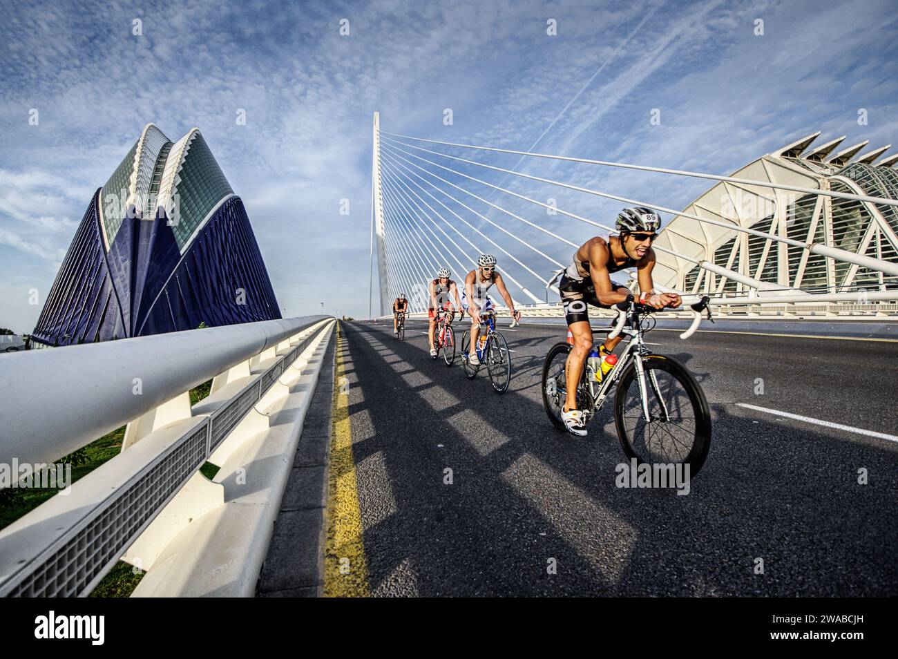 Cyclistes participant à un triathlon sur le pont moderne de la Cité des Arts et des Sciences de Valence alliant sport et architecture Banque D'Images